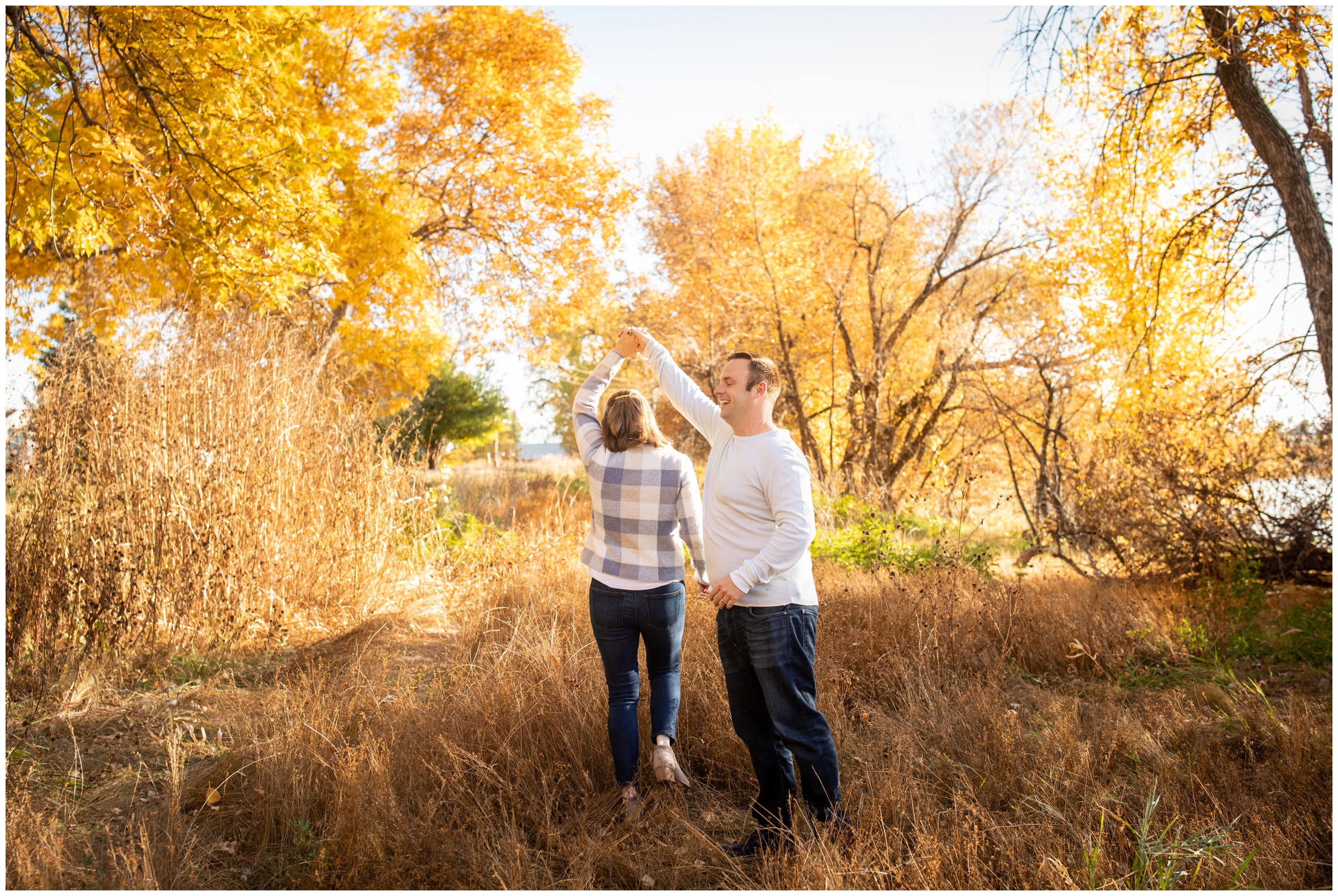 couple dancing in a field with fall foliage during couples engagement session in Mead Colorado 