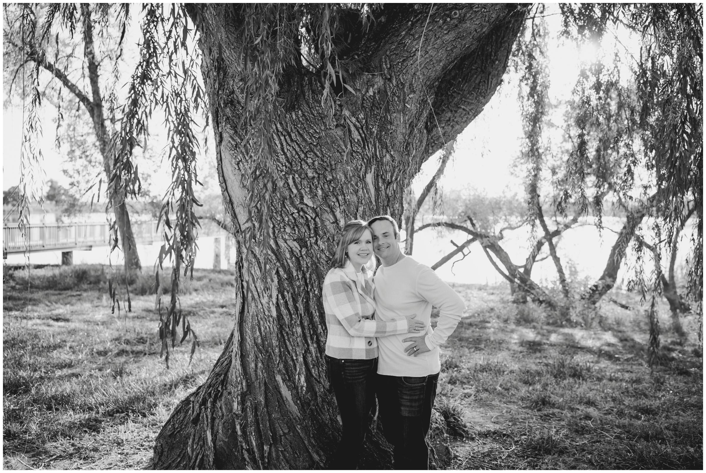 couple embracing under a willow tree during Colorado engagement couples portraits in Northern Colorado