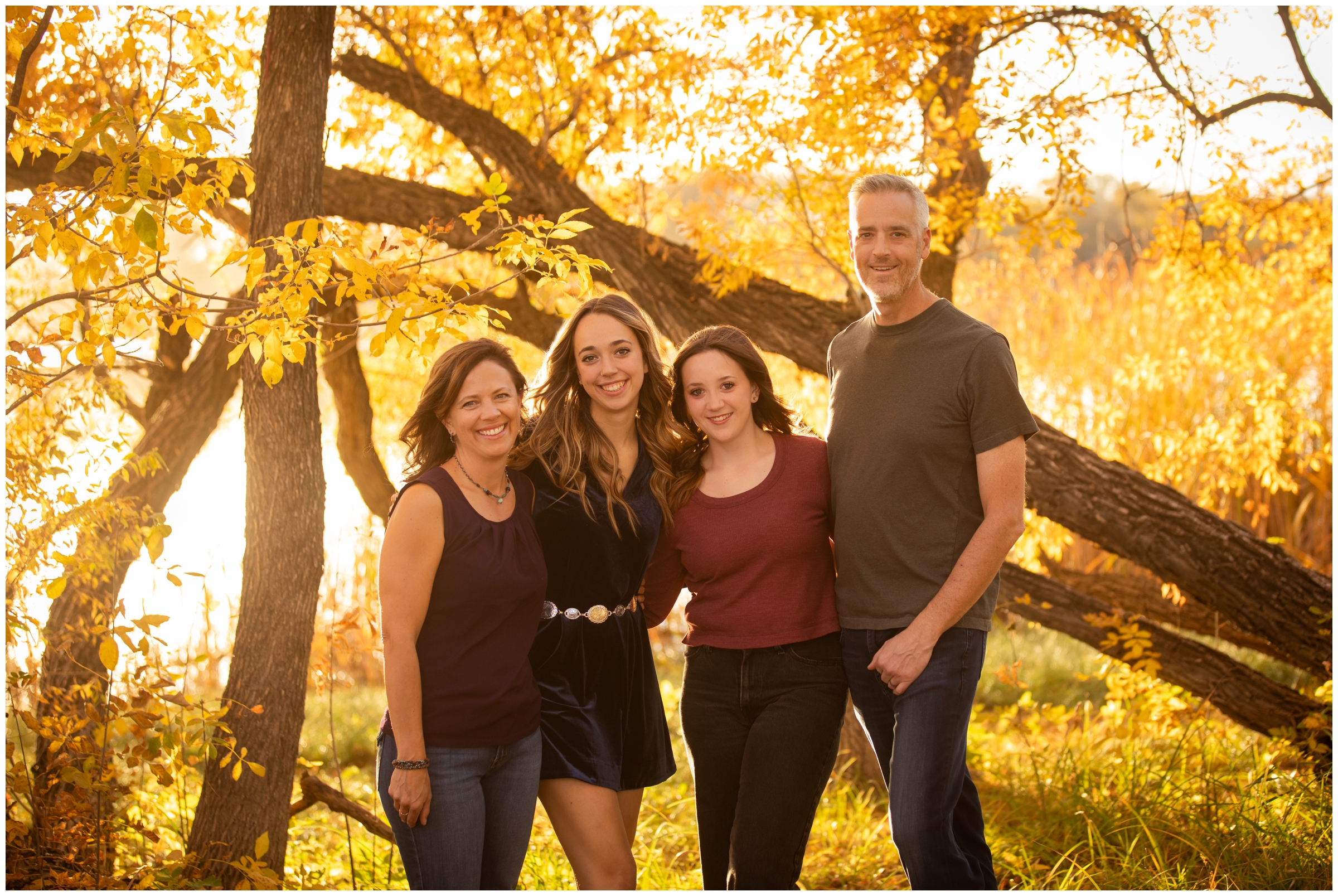 adult family posing with fall foliage during Mead Colorado family photos at Highland Lake 