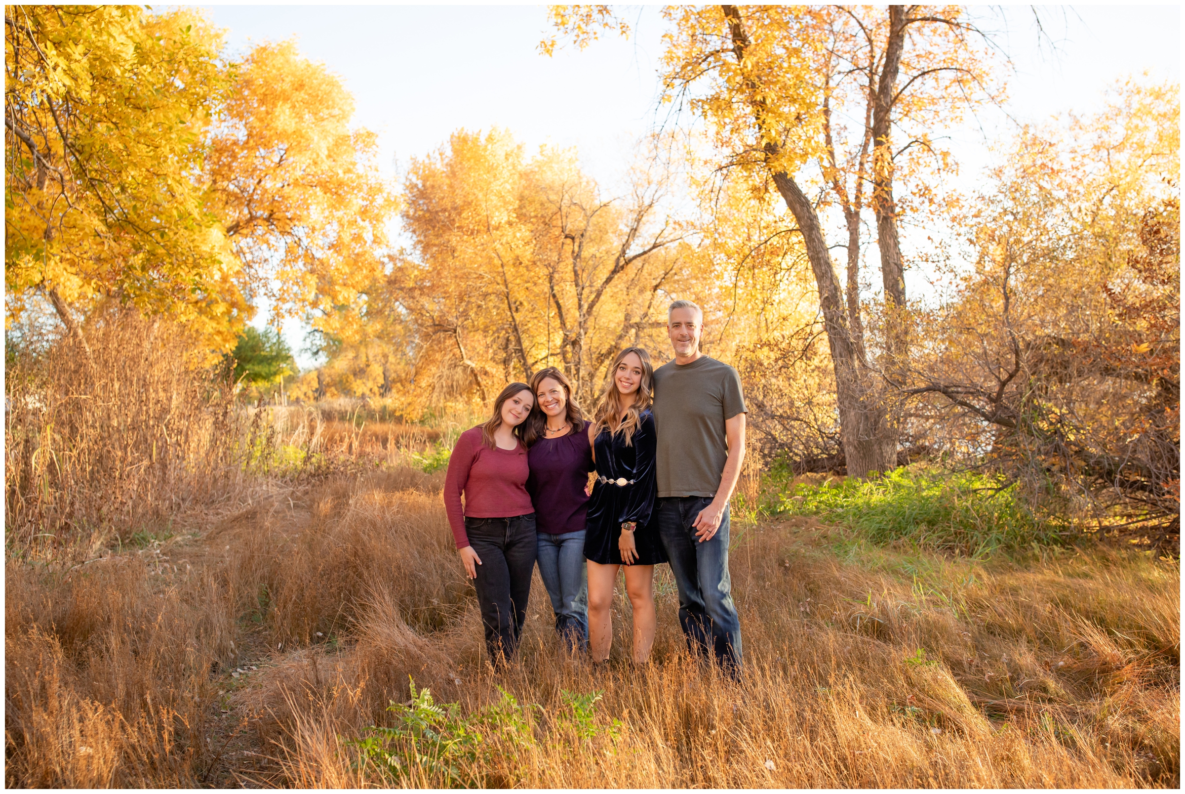 family posing in open field in Mead during fall Colorado family pictures by Plum Pretty Photography 