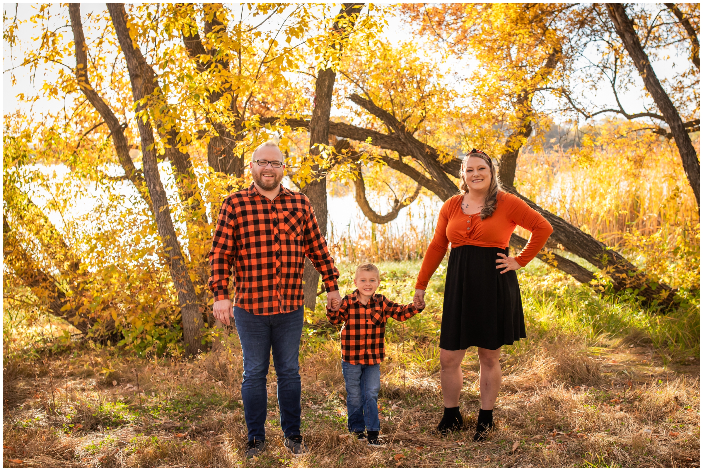family posing in front of colorful fall foliage during family pictures at Highland Lake in Mead Colorado 