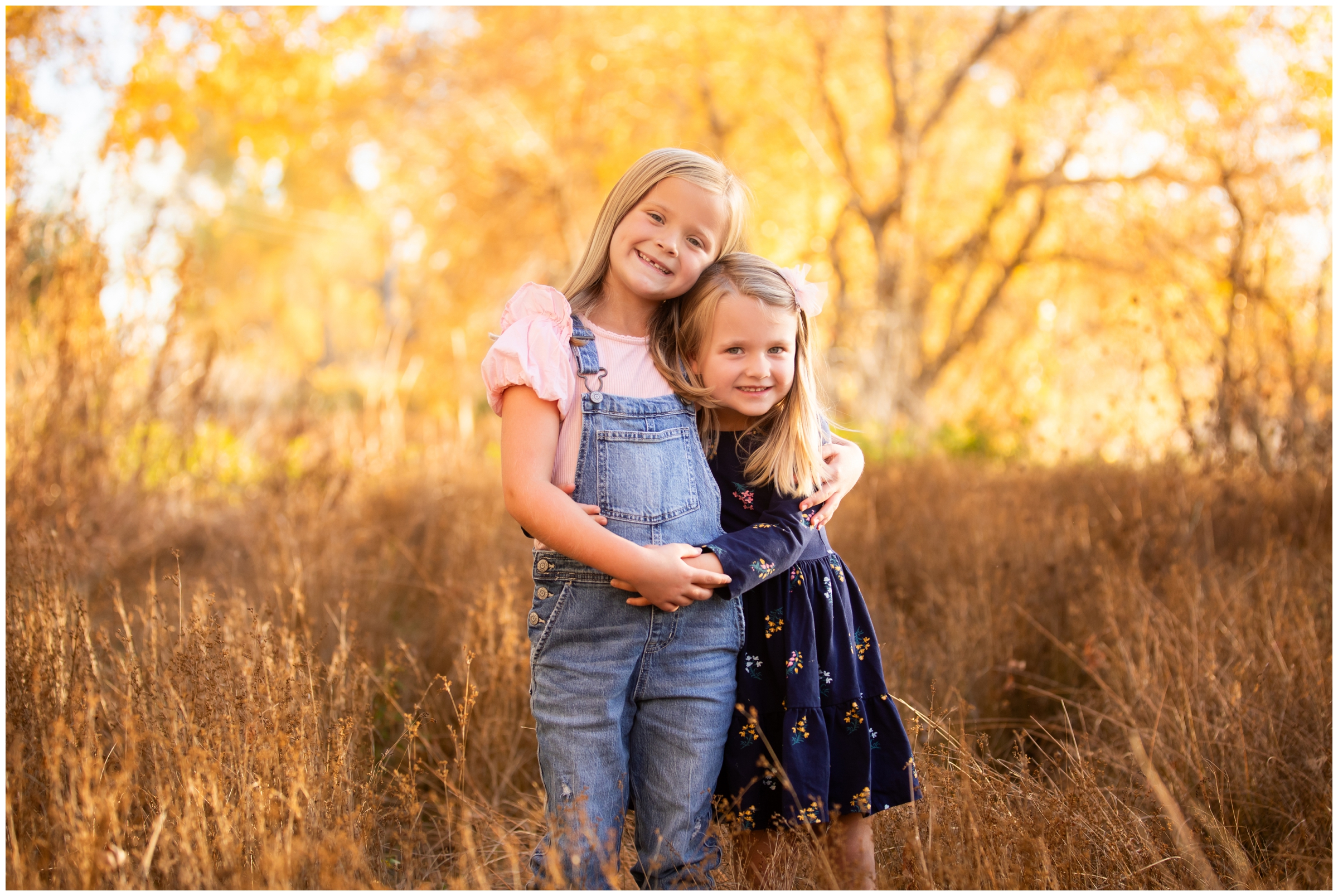 sisters hugging during fall family pictures by Mead Colorado photographer Plum Pretty Photography 