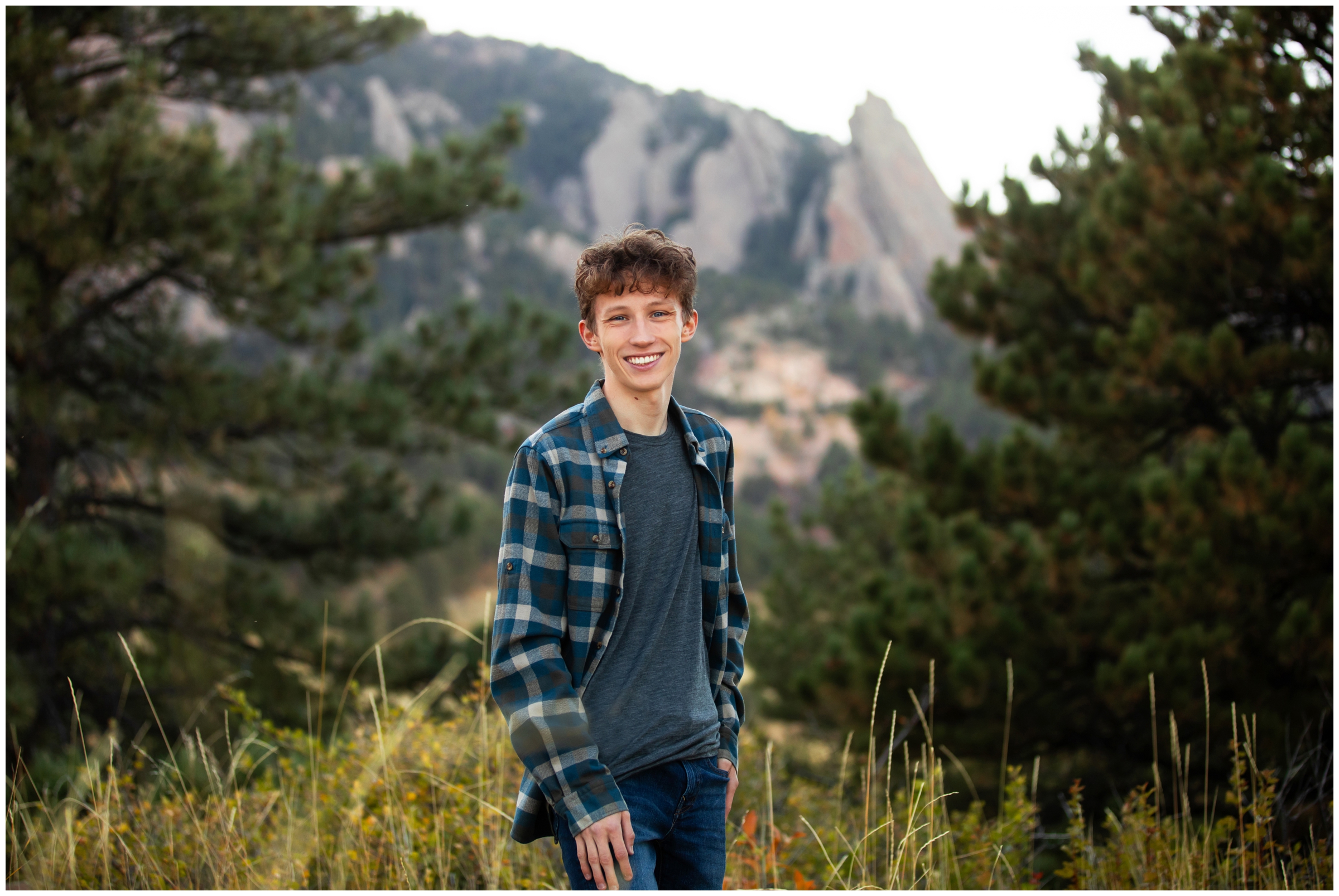 teen guy posing in front of flatirons mountains during Boulder Colorado senior photos by Plum Pretty Photography 