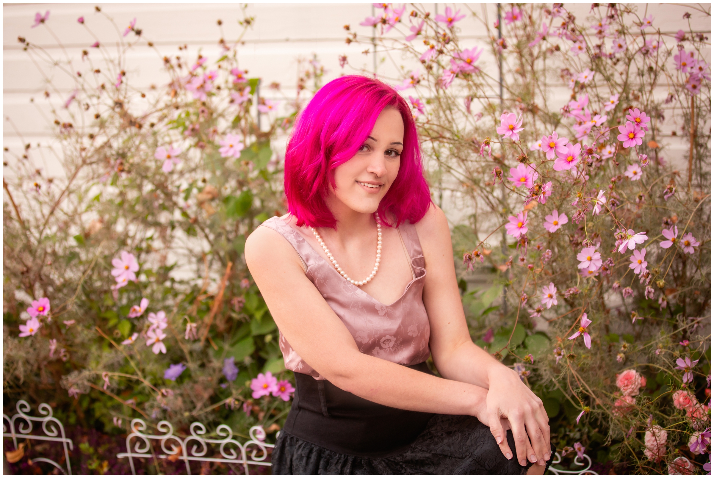 teen with hot pink hair posing in flower garden during Colorado senior pictures by Niwot photographer Plum Pretty Photography 