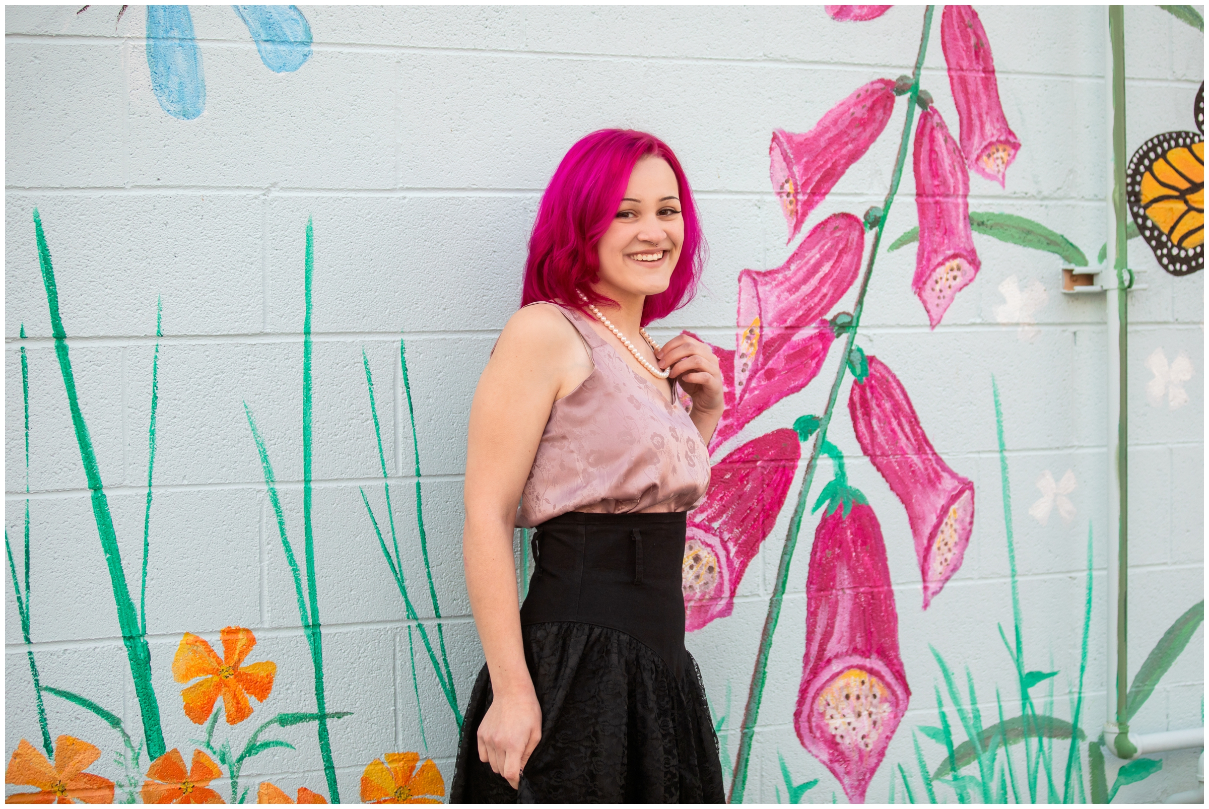 teen posing in front of wall mural during artsy senior photography session in Niwot Colorado  