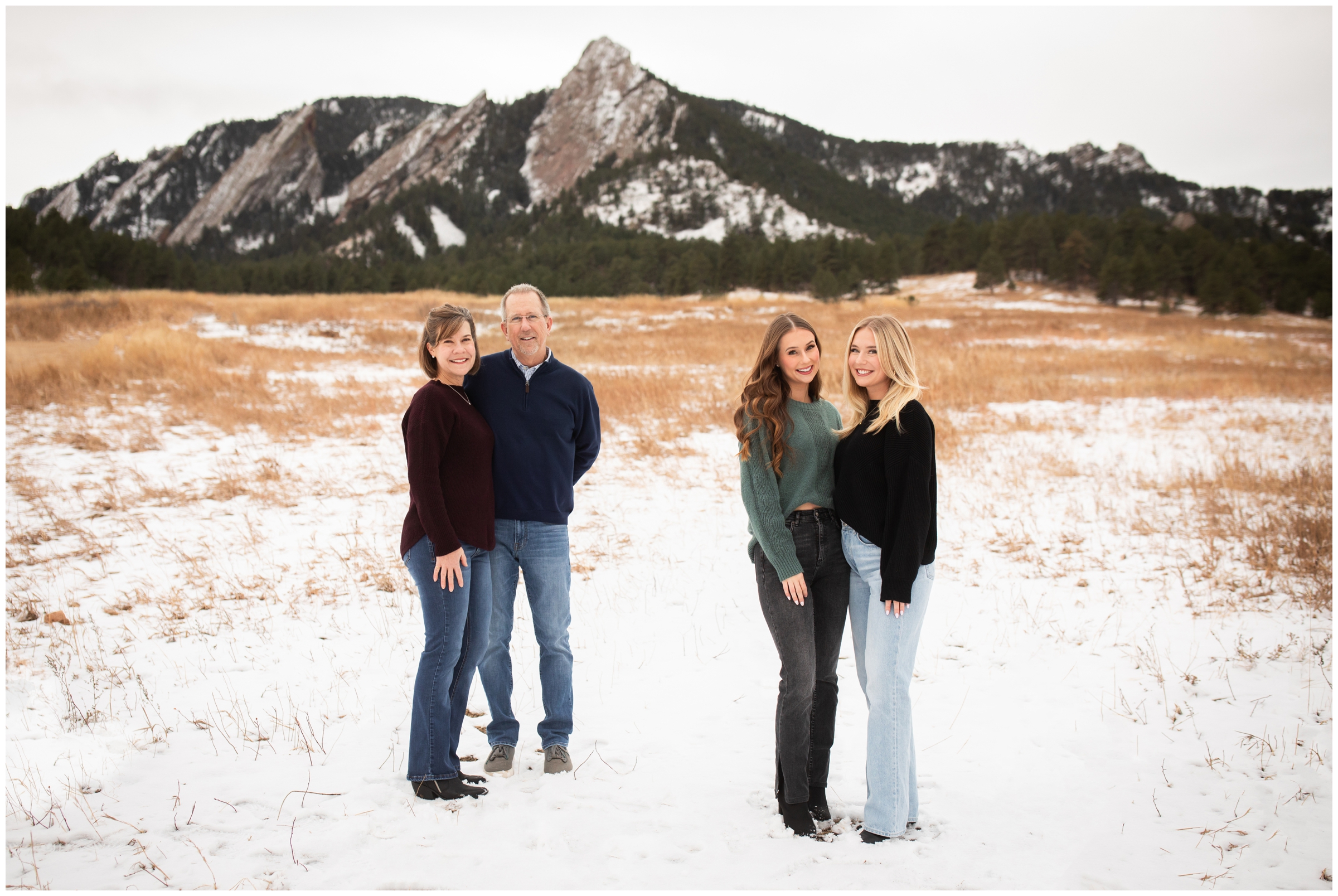 parents and adult children posing in the snow during Boulder flatirons family photos at Chautauqua Park
