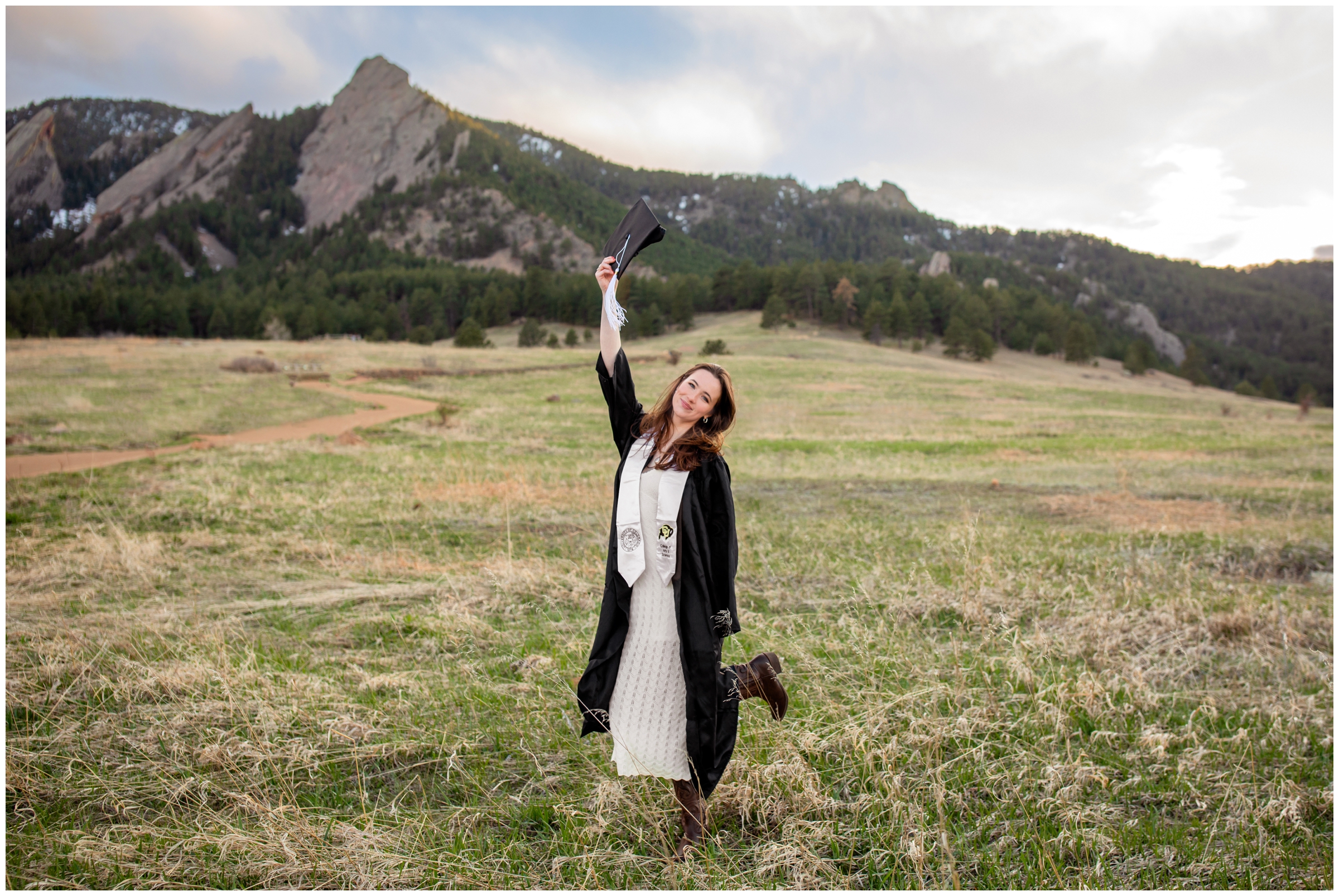 woman throwing graduation cap in the air during college senior photos from CU Boulder  