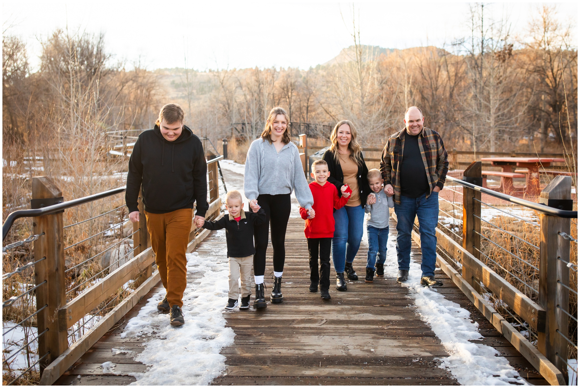 family walking on bridge during candid family photos in Lyons Colorado 
