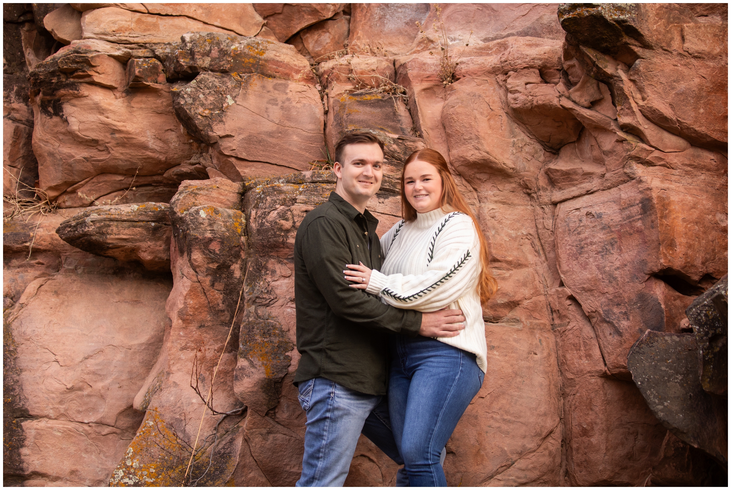couple posing in front of red rock formations during Colorado winter engagement pictures by Plum Pretty Photography