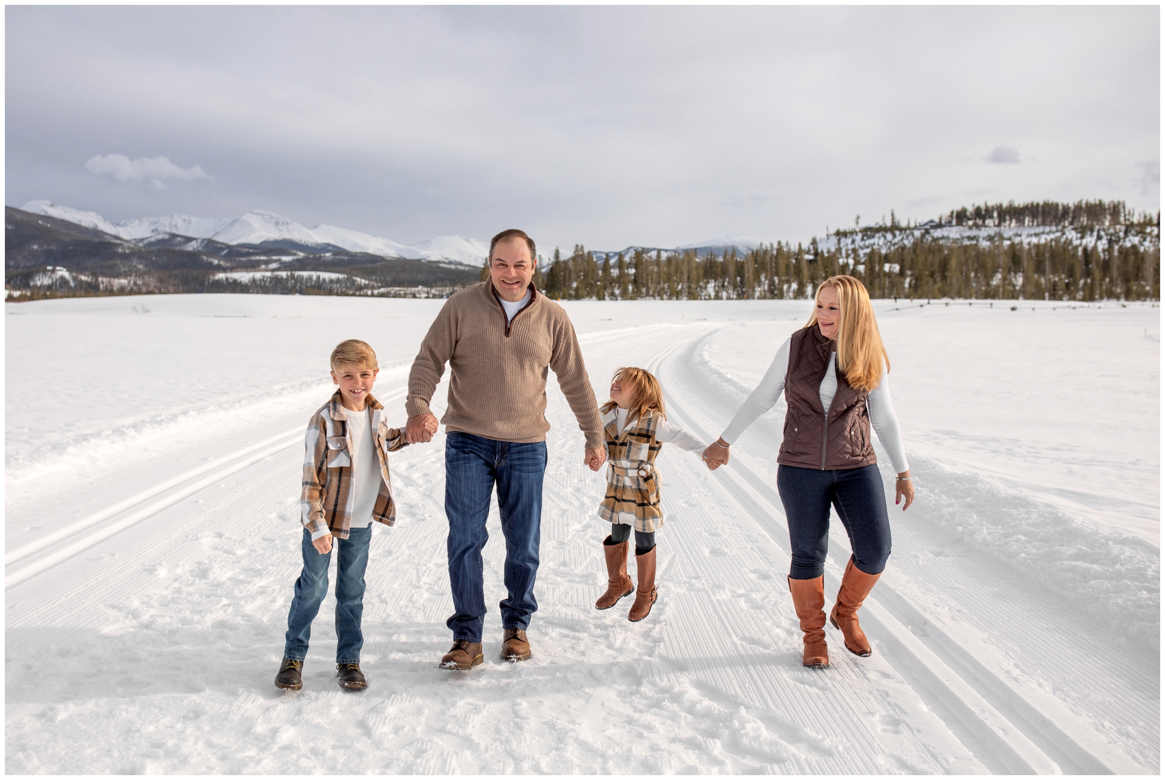 family walking in the snow during candid family pictures in Winter Park Colorado by Plum Pretty Photography