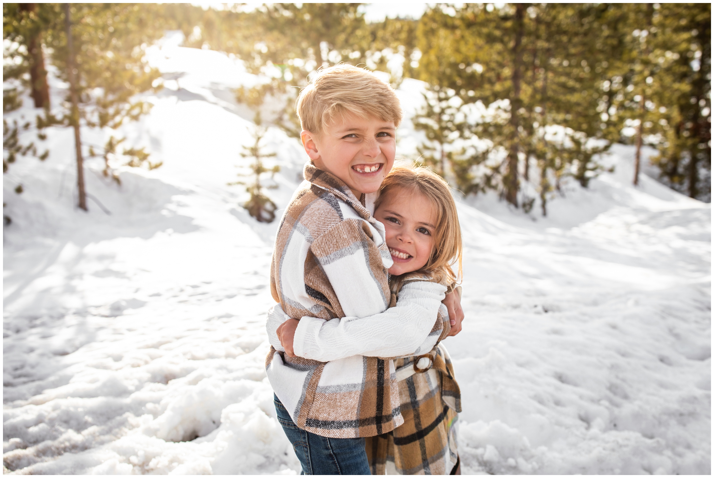 brother and sister hugging in the snow during Winter Park Colorado family pictures
