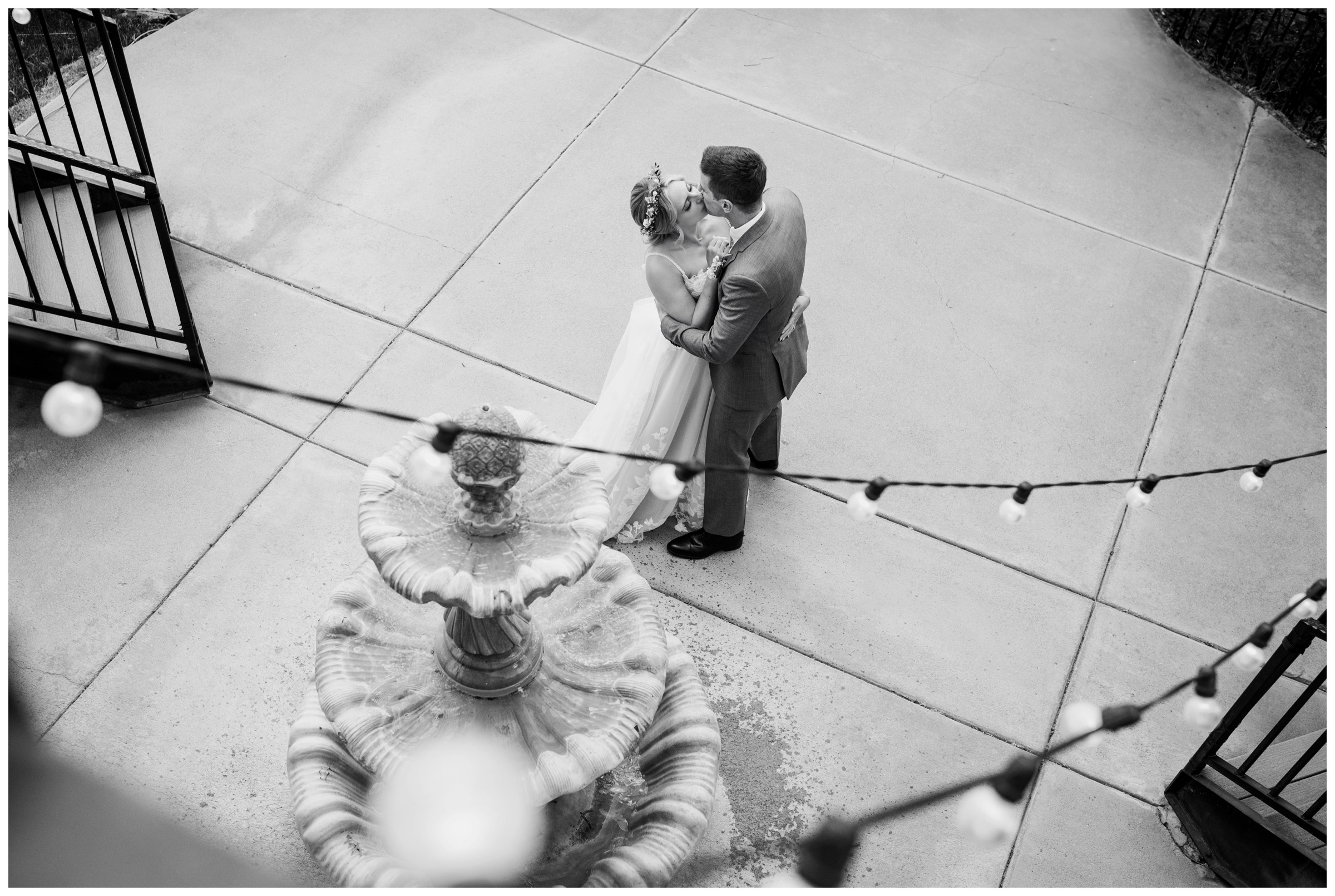 bride and groom kissing by water fountain at Lionscrest Manor during Lyons Colorado spring wedding