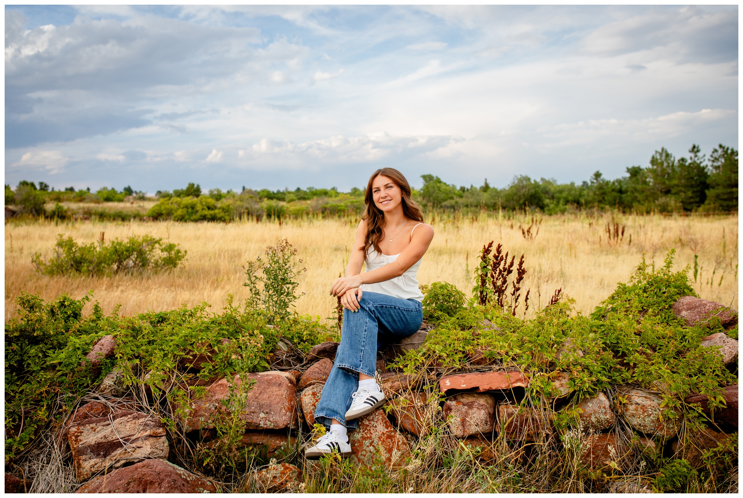 teen sitting on rock pile at South Mesa Trail in Boulder Colorado