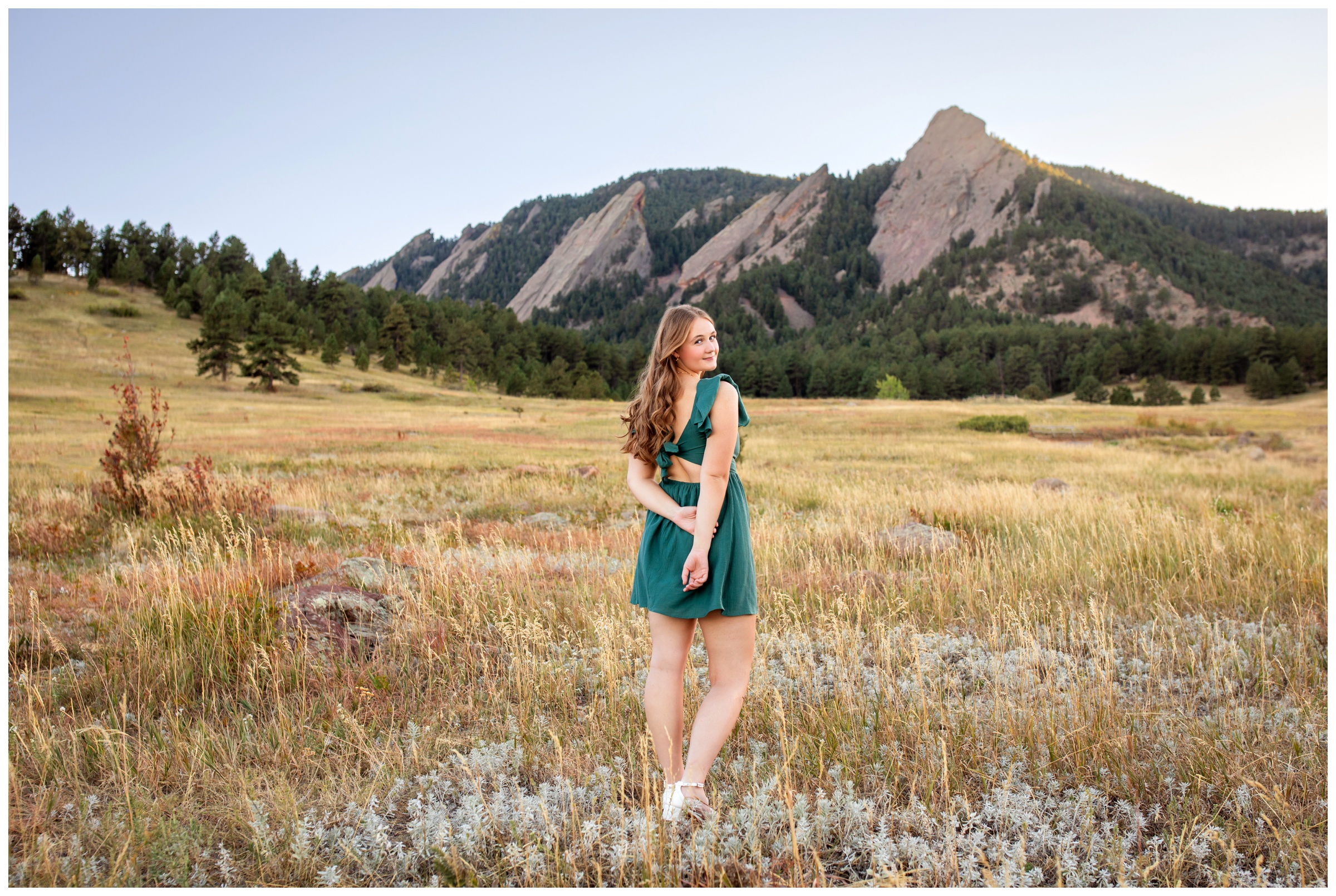 teen posing in front of Boulder flatirons during senior pictures at Chautauqua Park in Colorado