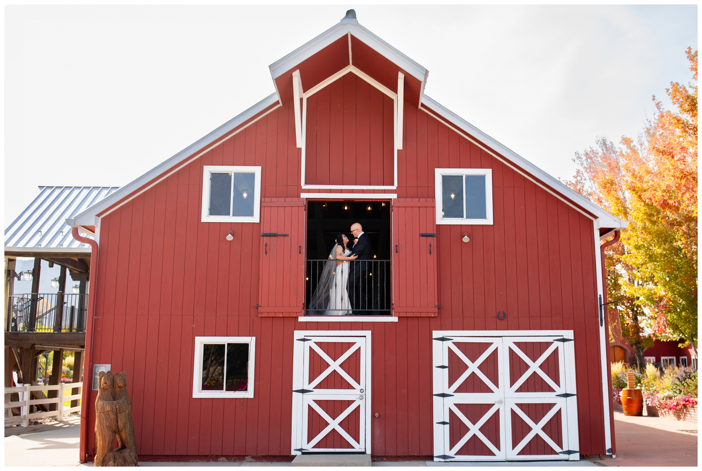 couple posing in red barn during Larkspur Colorado fall wedding pictures at Crooked Willow Farms
