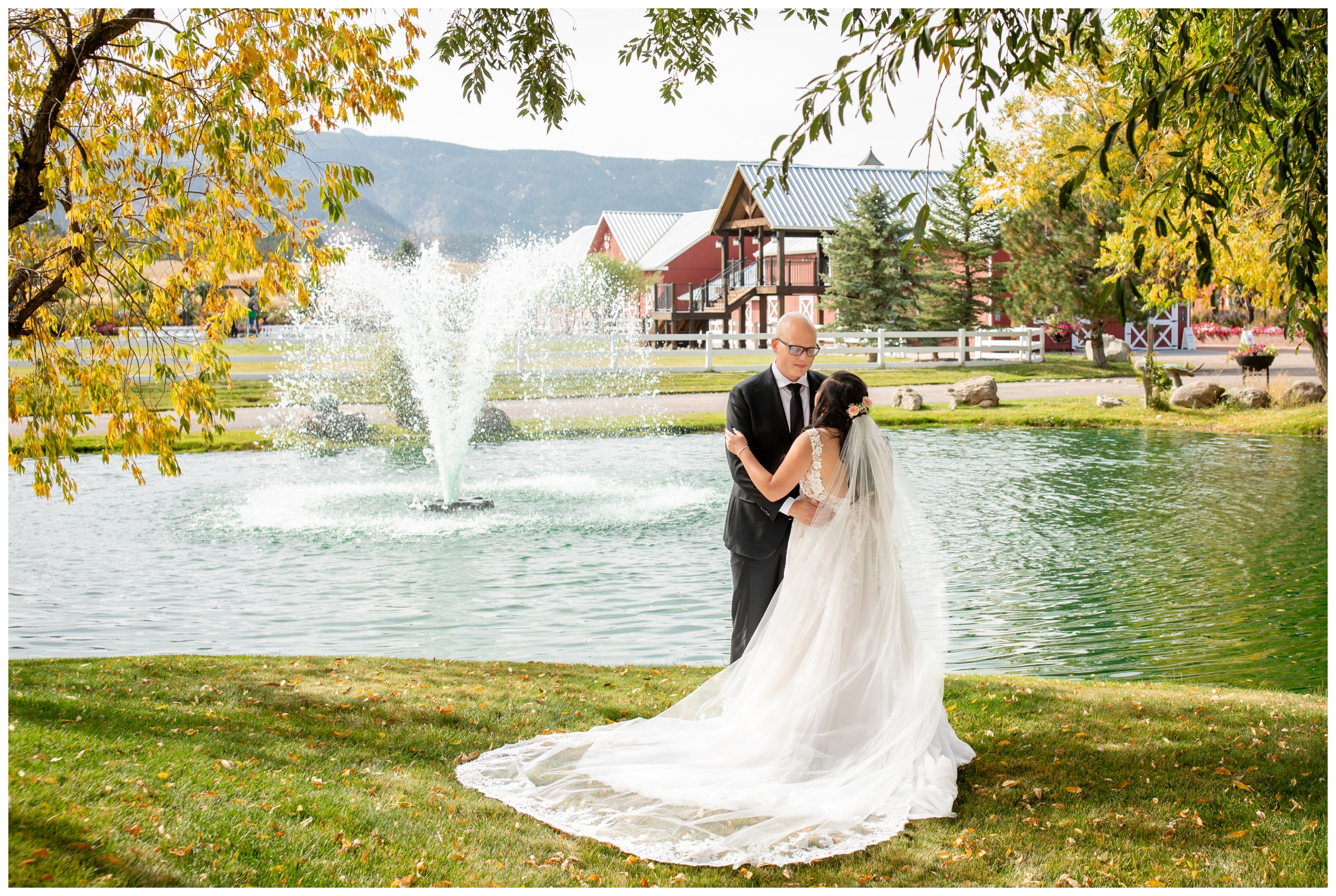 couple posing by water fountain during Larkspur Colorado fall wedding photos at the venue at Crooked Willow Farms