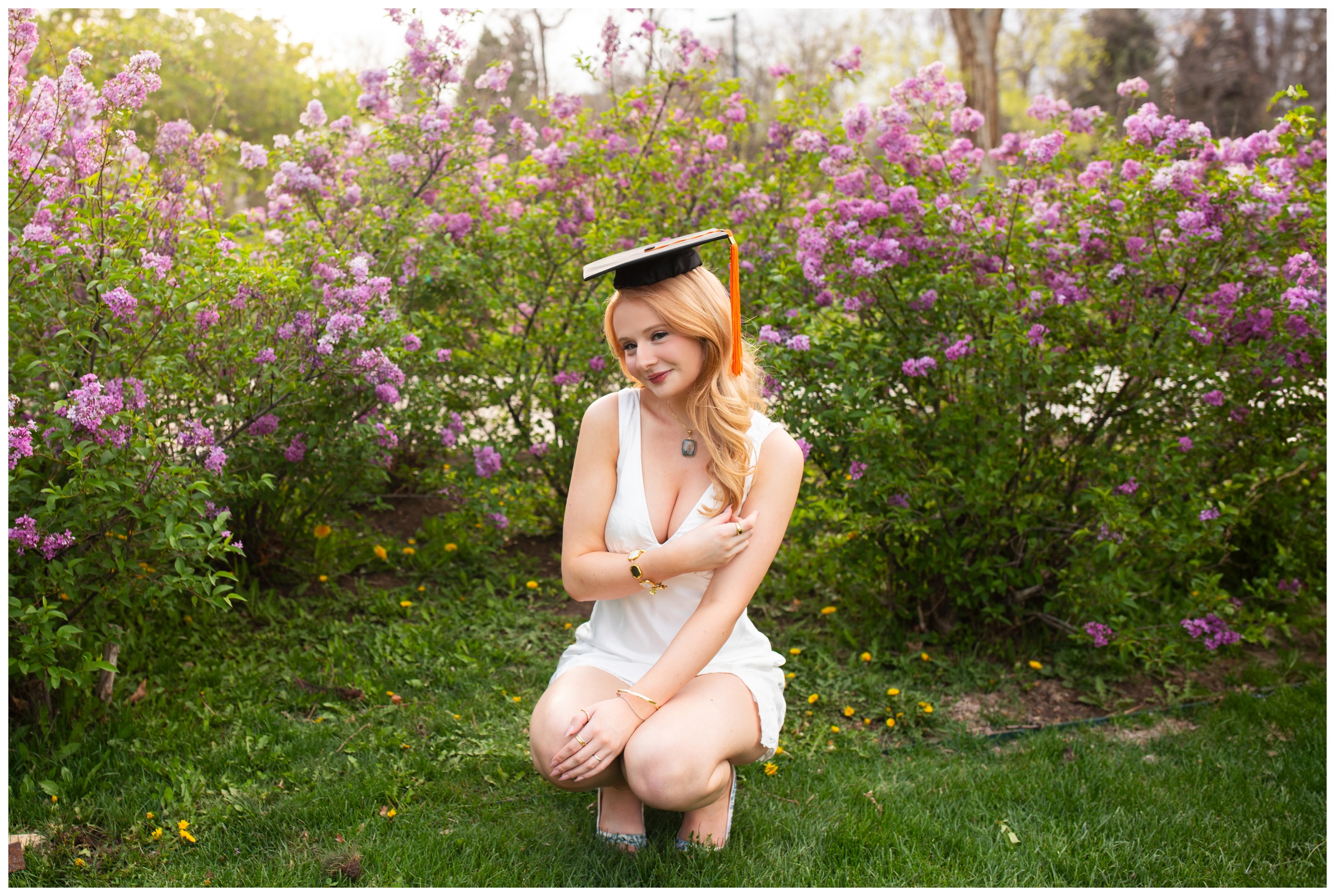 woman posing in front of lilac bushes on CU campus during Boulder Colorado college graduation photography session