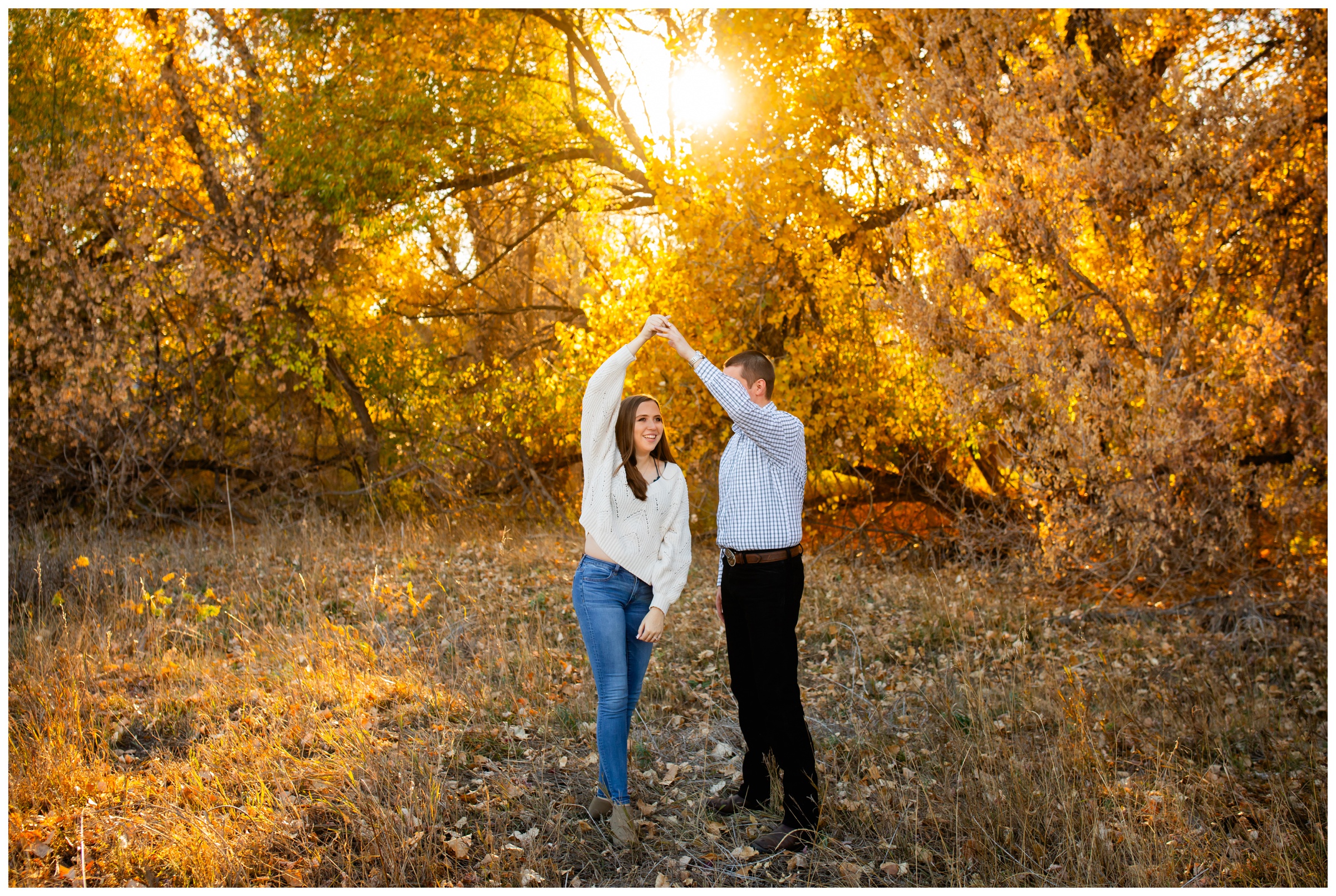couple dancing in a field during Fort Collins Colorado engagement photography session during fall