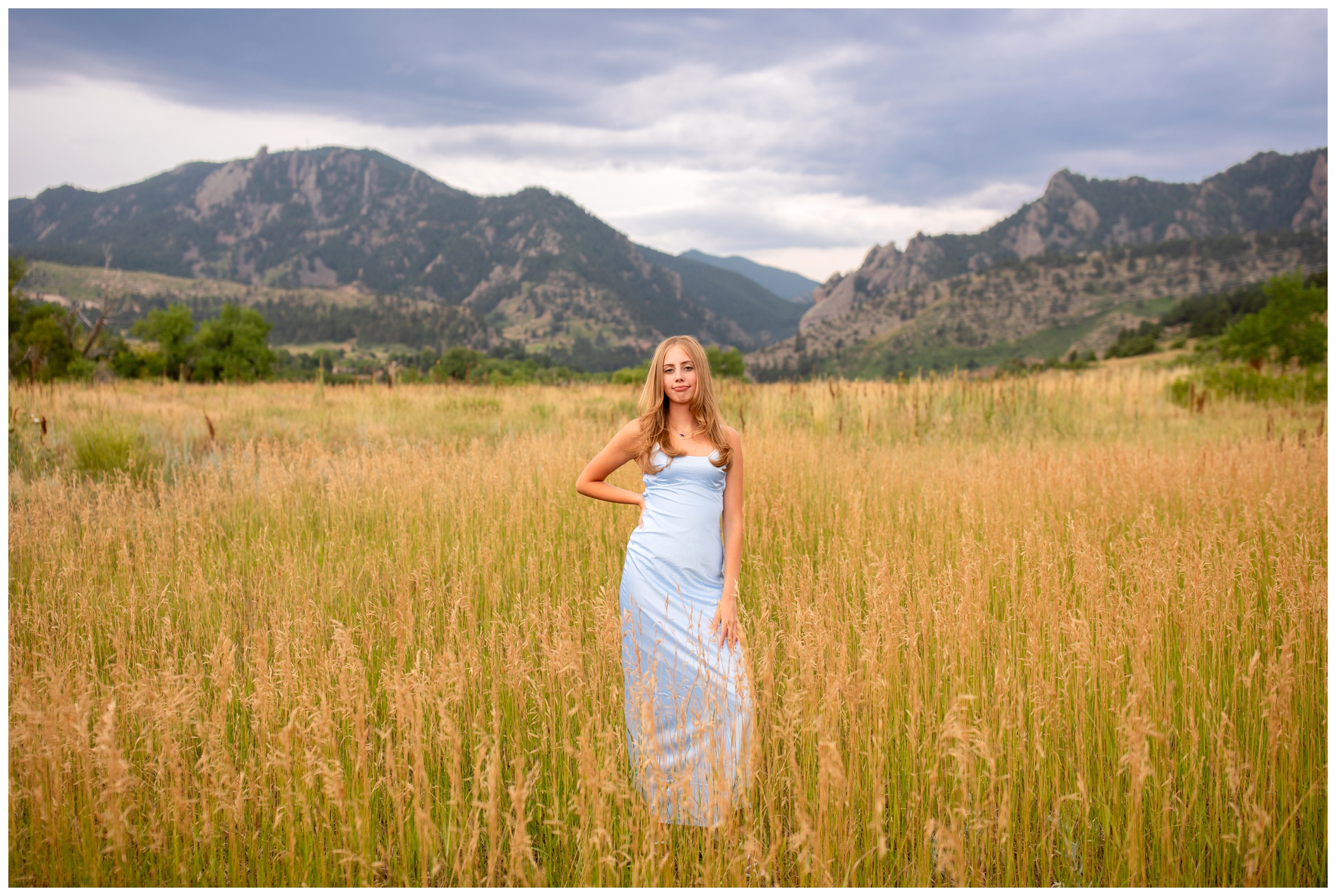 teen posing in mountain field in prom dress during Boulder Colorado senior pictures by Plum Pretty Photography 