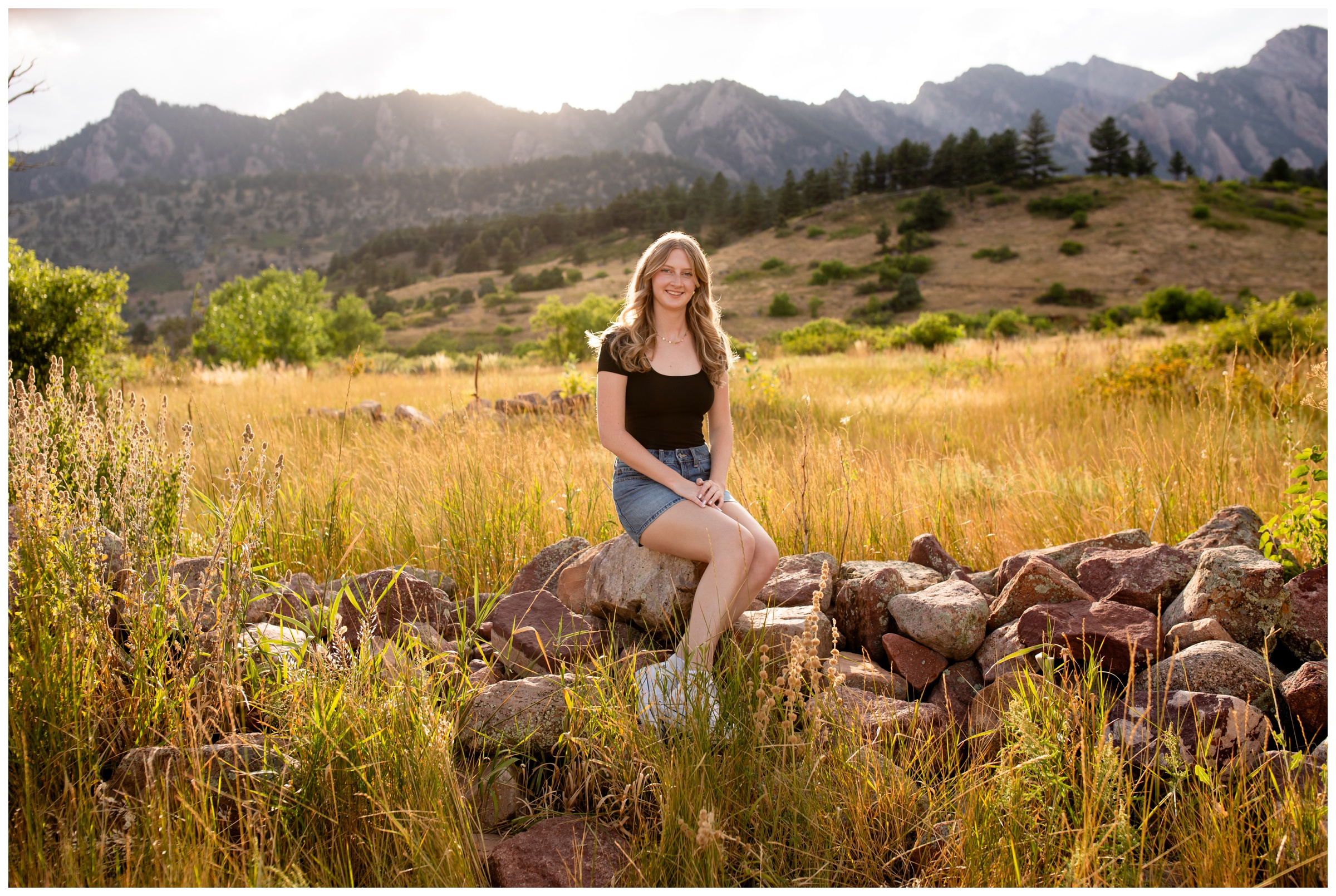 teen sitting on rock pile at South Mesa during Berthoud High school senior portraits