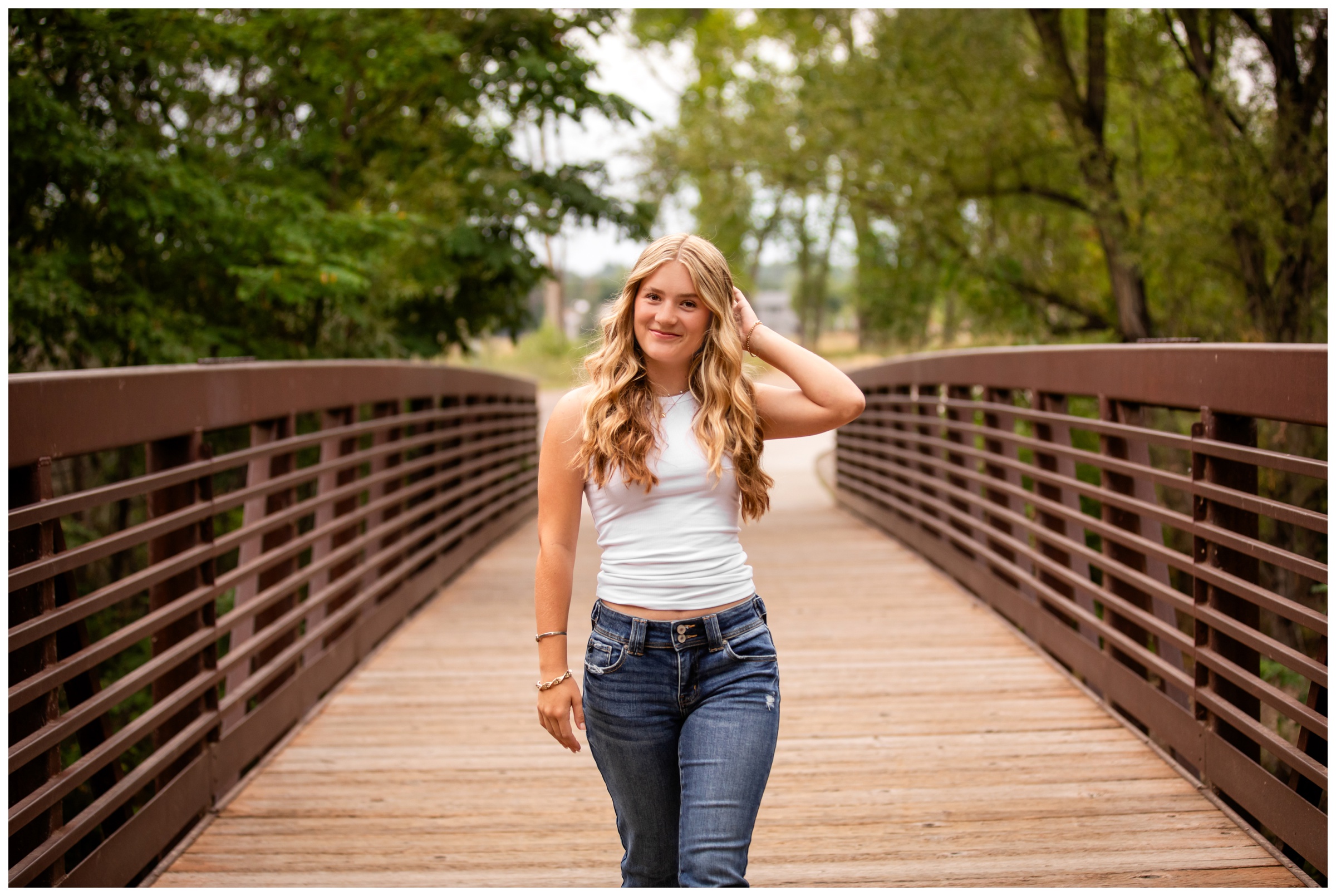 teen walking on bridge at Golden Ponds during Silver Creek High senior pictures in Longmont