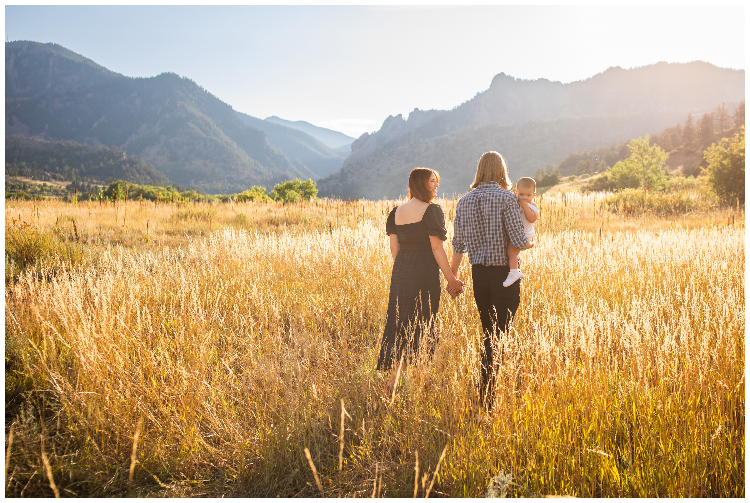 family walking through mountain field in Boulder during candid family photos 