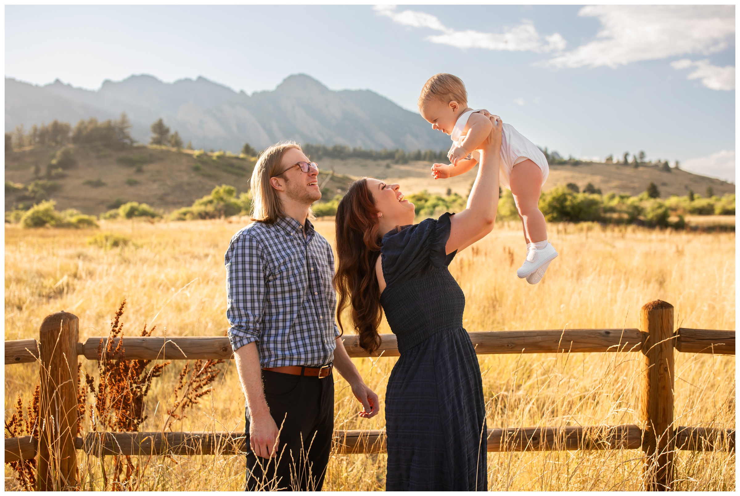 mom lifting baby into the air during candid family photos in Boulder Colorado 