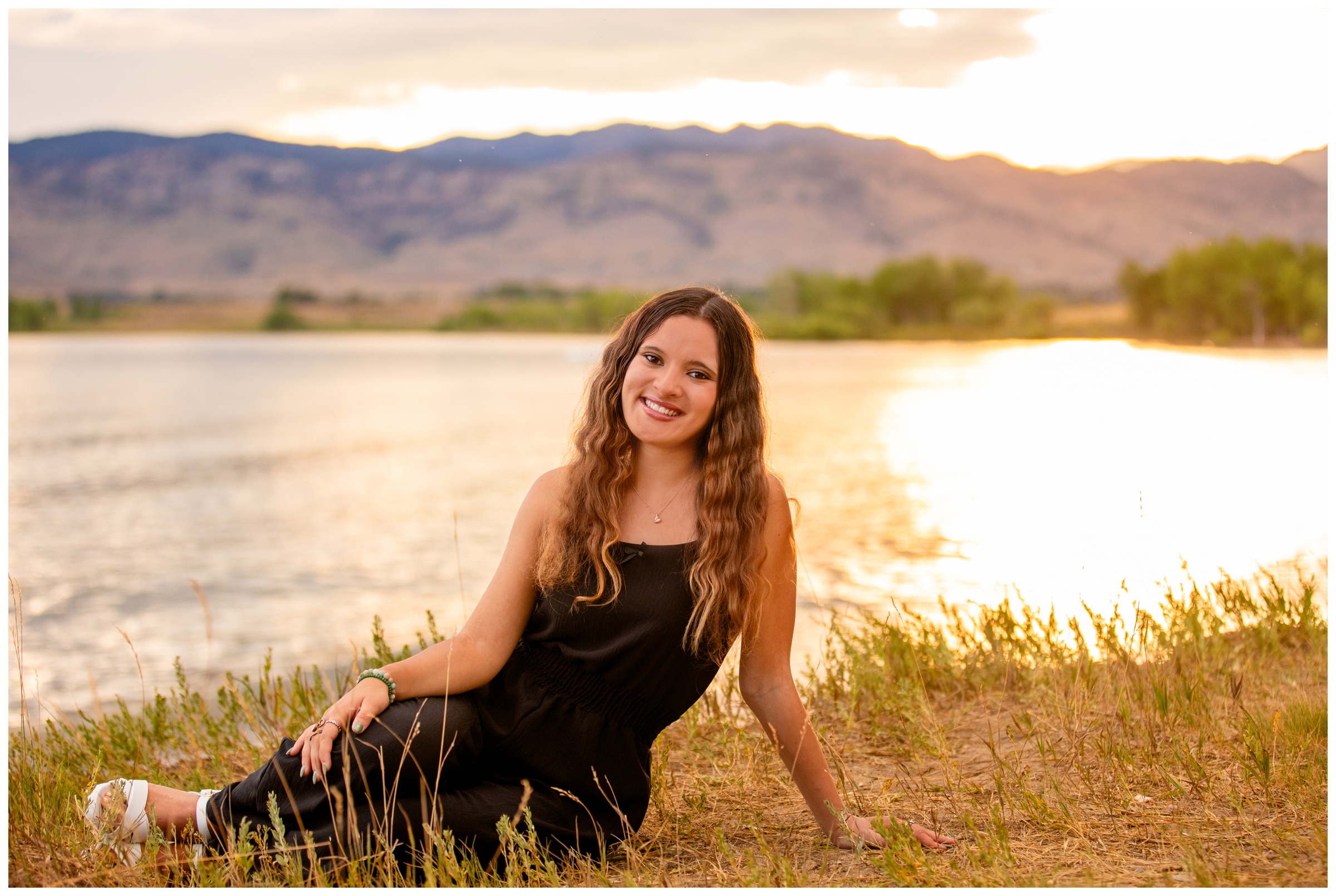 teen posing in front of mountain lake during sunset senior pictures in Boulder Colorado 
