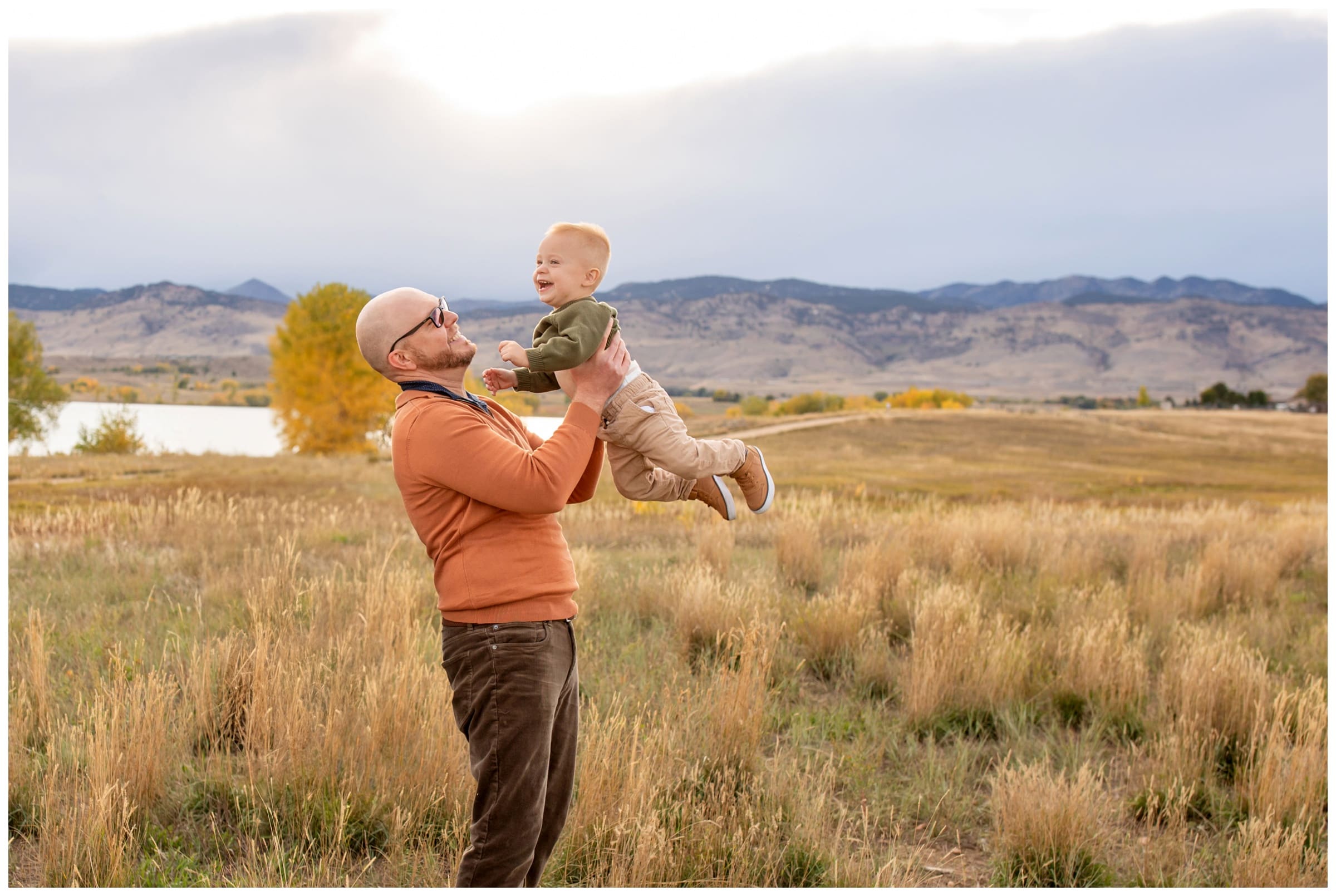 dad lifting son into air during candid fall mini session pictures at Coot Lake Boulder 