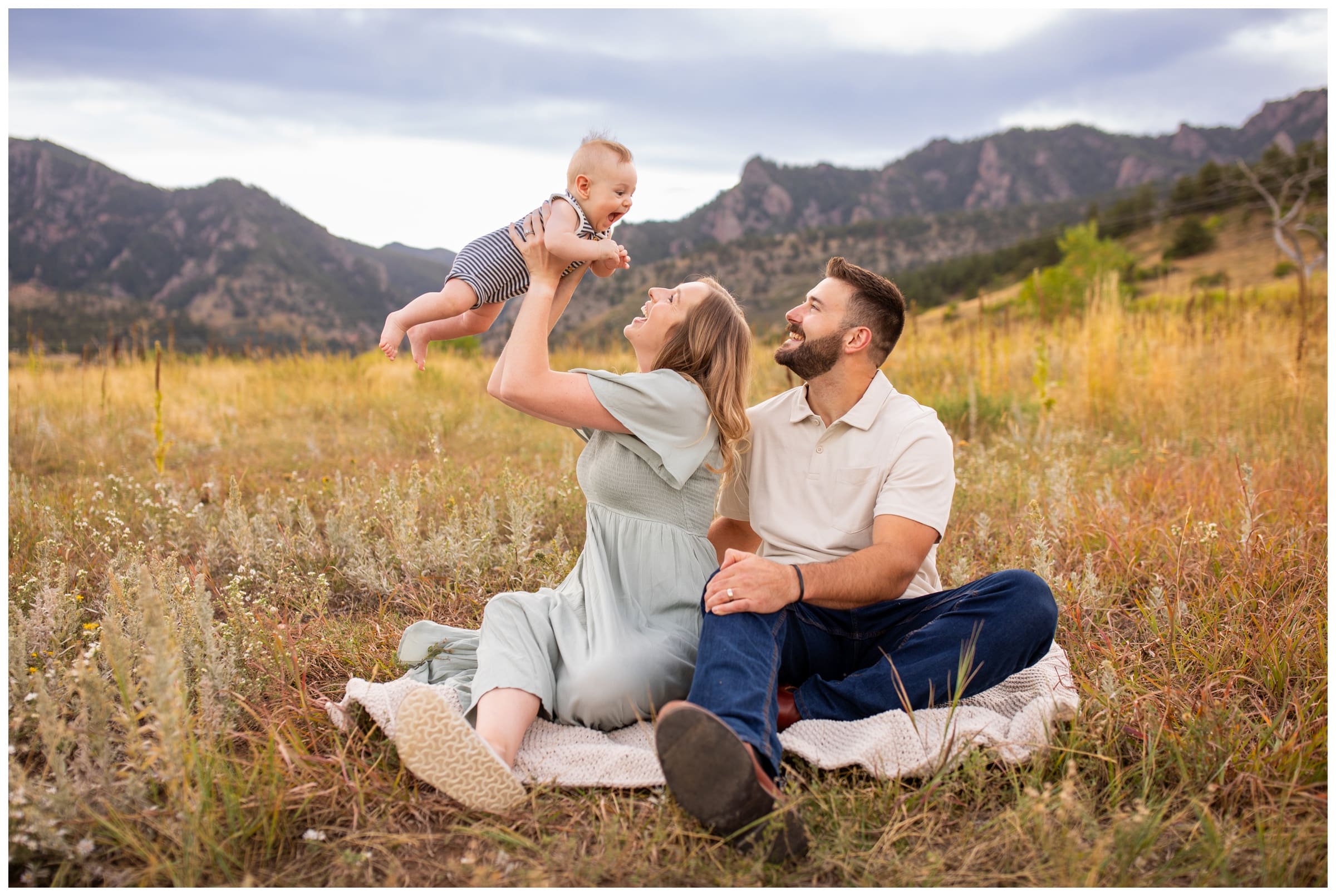 family cuddling on blanket during Colorado candid photography session in South Mesa Boulder 