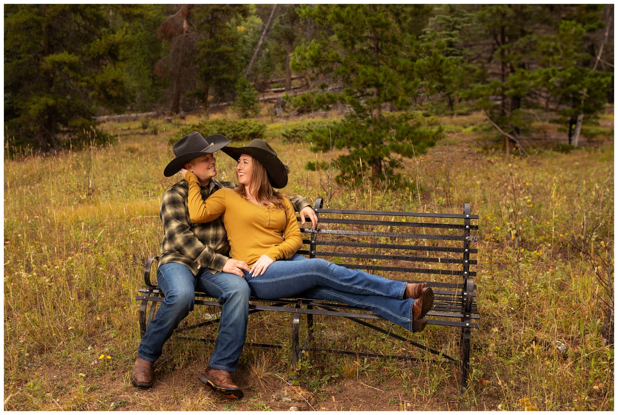couple cuddling on bench during Evergreen Colorado engagement portraits at Frosberg Park 