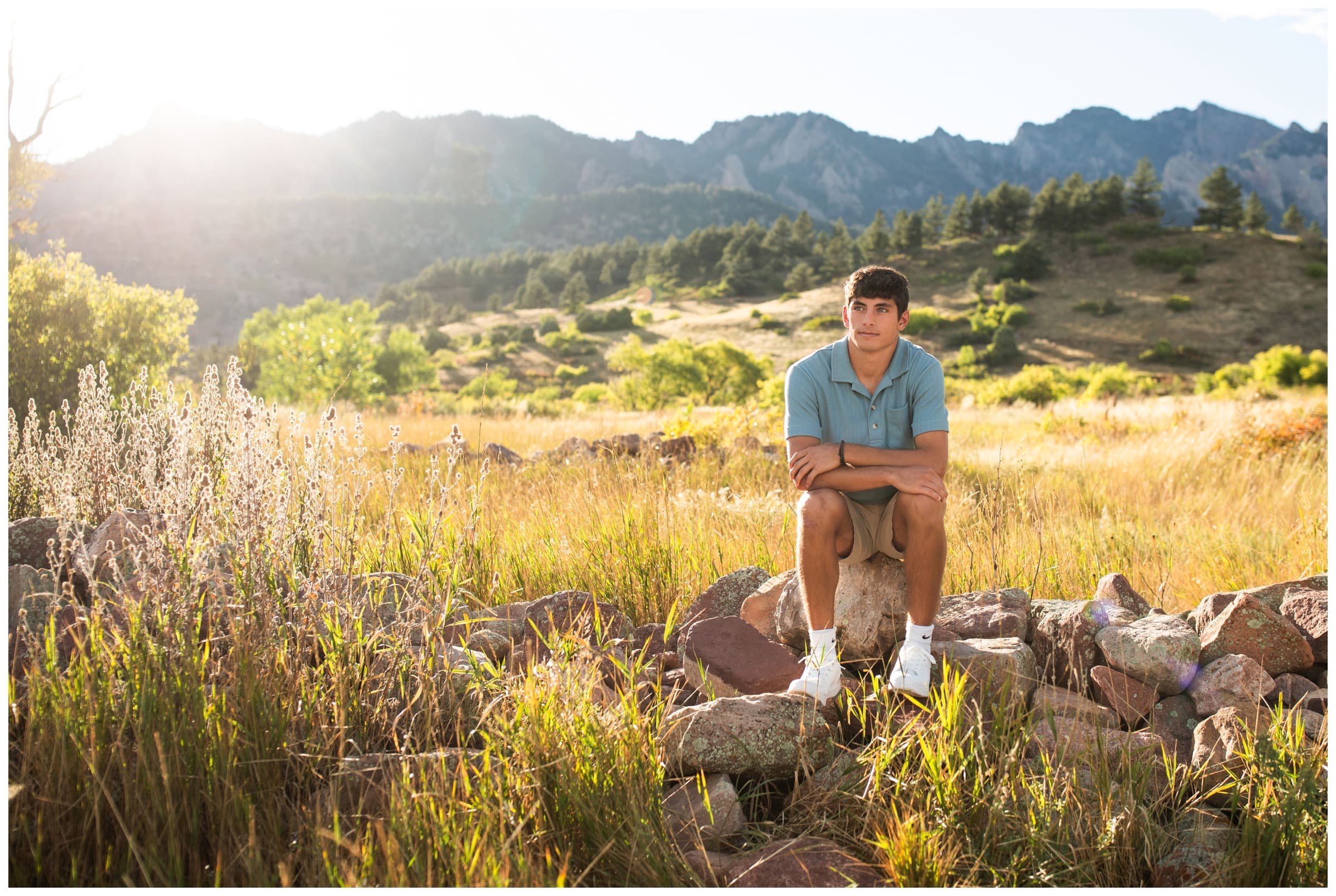 teen guy sitting on rock pile during Silver Creek High School senior pictures in Boulder 