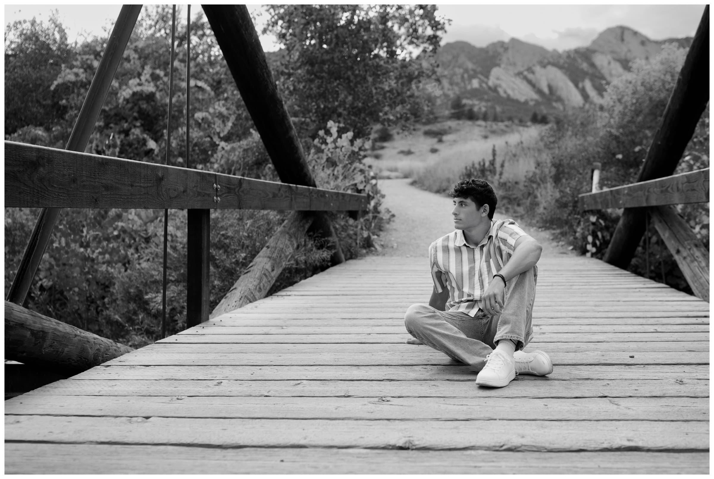 teen sitting on wooden bridge during Silver Creek High School Colorado senior photos by Plum Pretty Photography 
