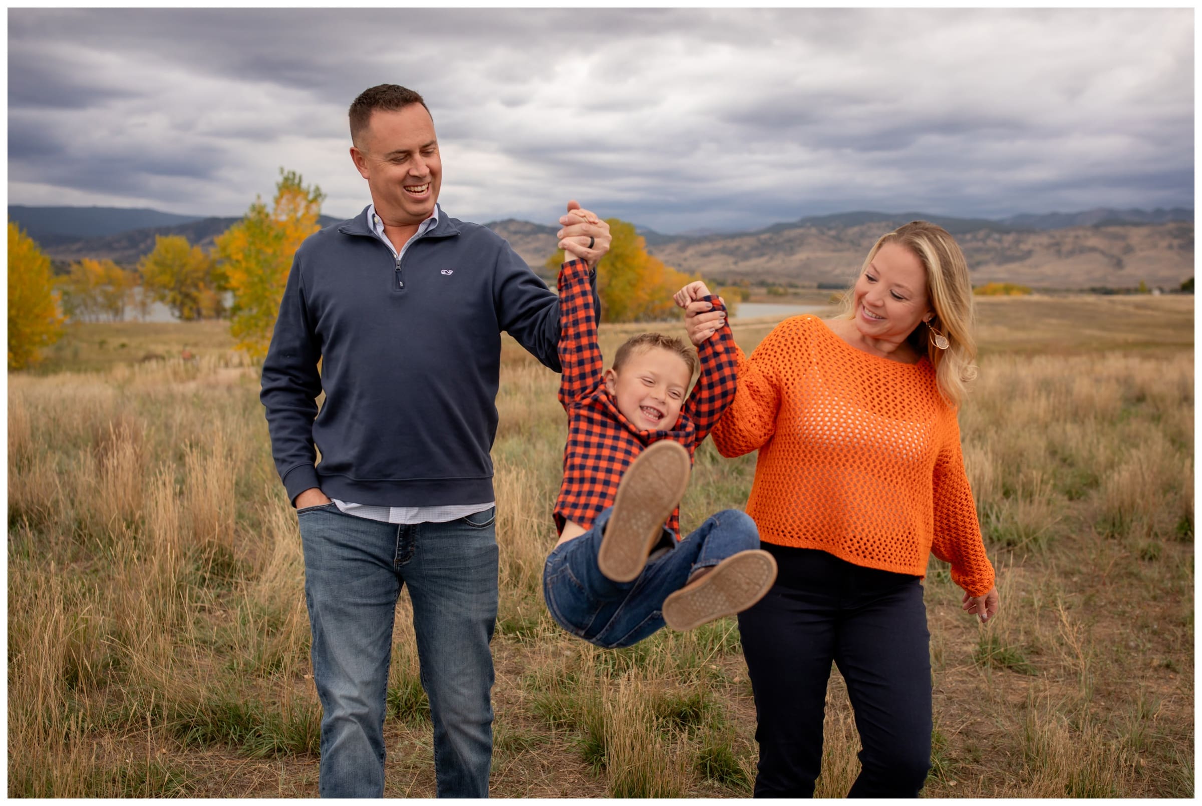 parents swinging son during candid family mini session in Boulder Colorado
