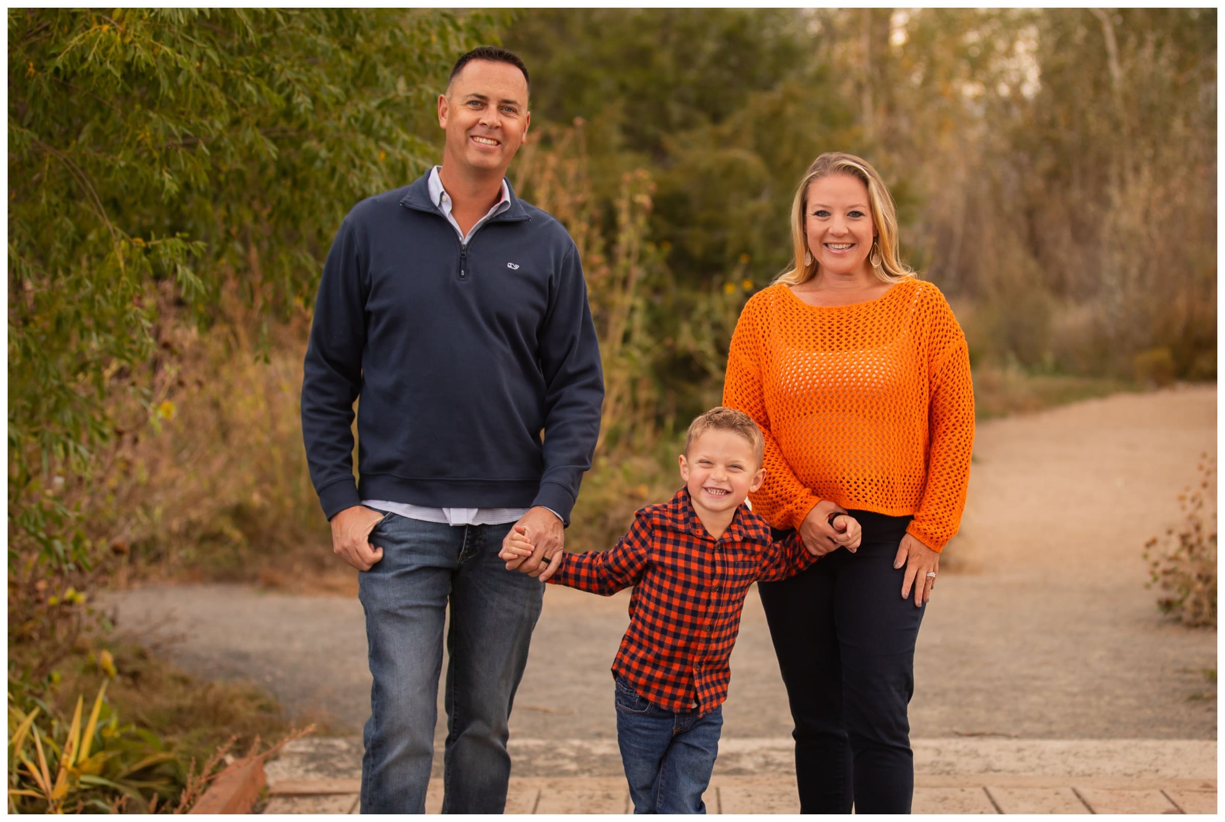 family posing on wooden bridge during Boulder Colorado family fall mini photography session by Plum Pretty Photography 
