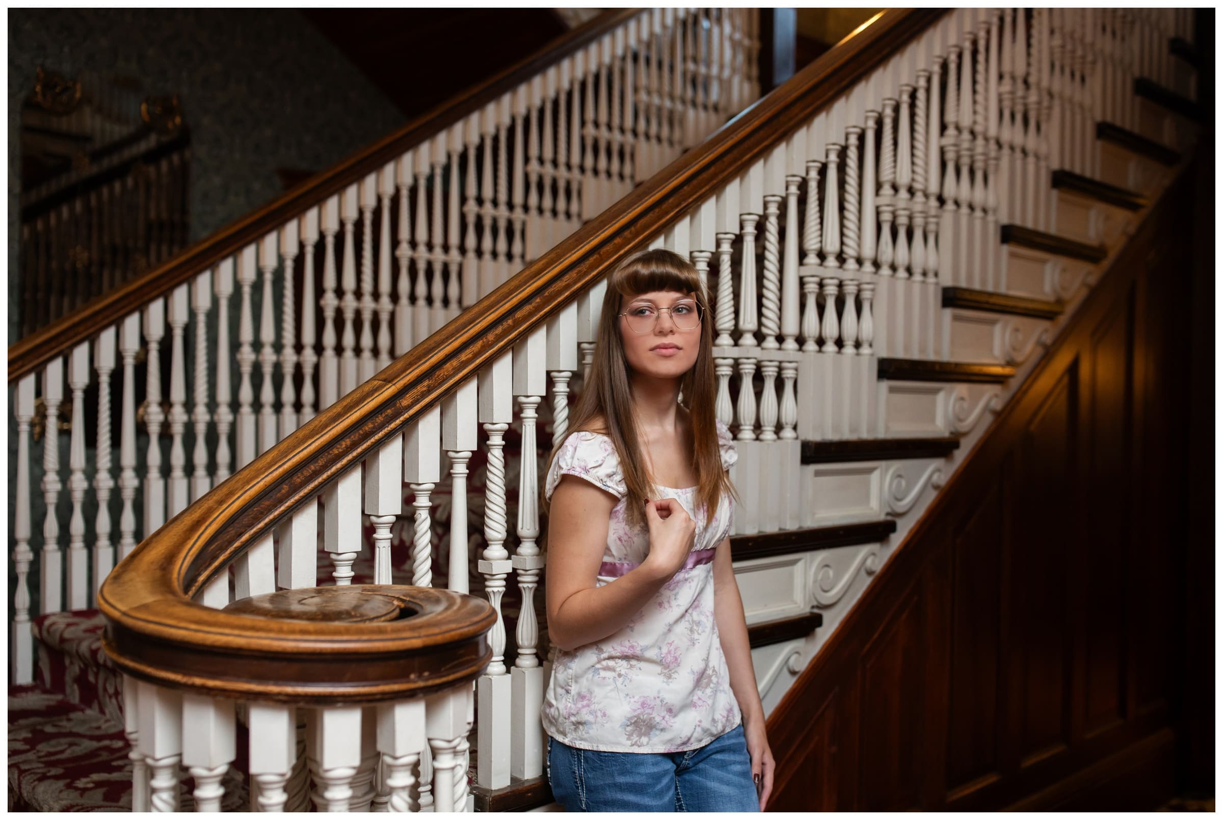 teen leaning against staircase during unique Colorado senior photography session at the Stanley Hotel in Estes Park 