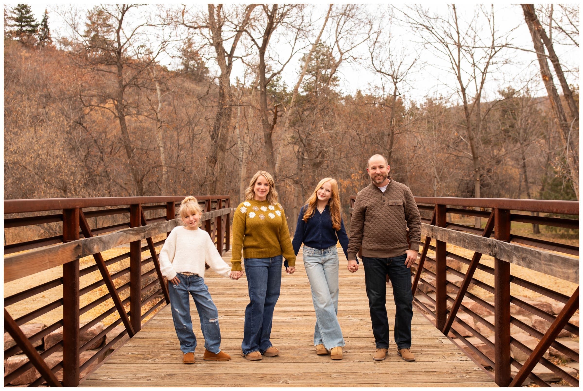 family posing on bridge at Lavern Johnson park during Colorado fall family portraits