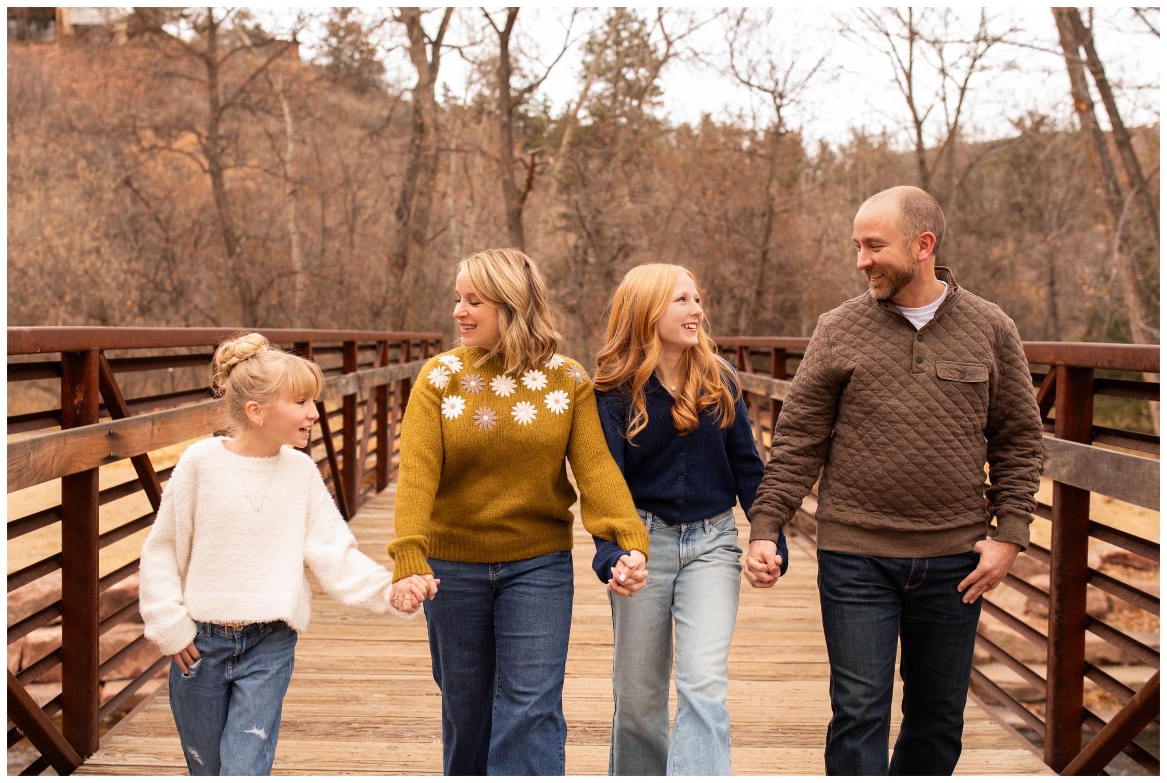 family walking on a bridge during candid photography session in Lyons Colorado
