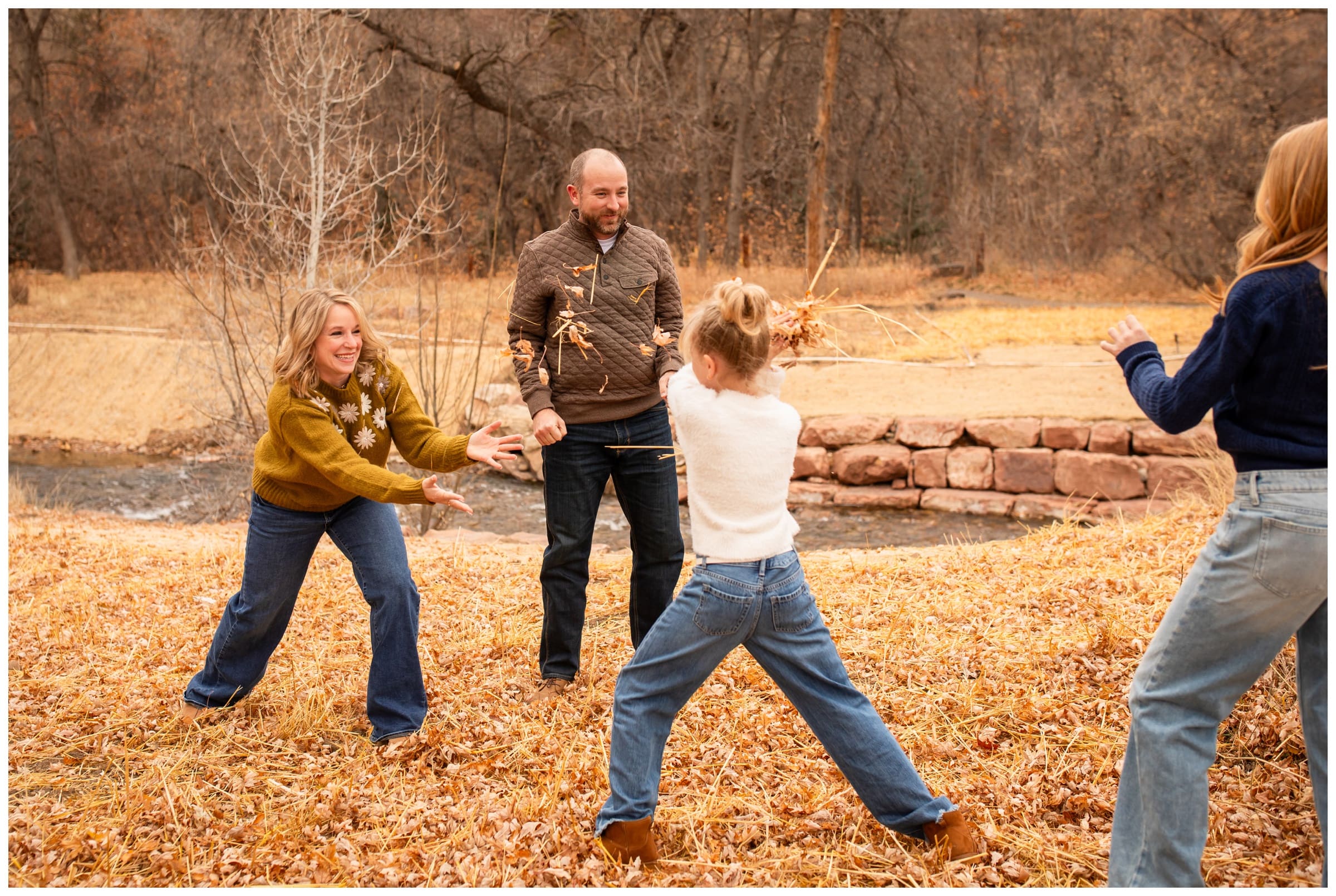 family throwing leaves during candid photography session at Lavern Johnson Park in Colorado