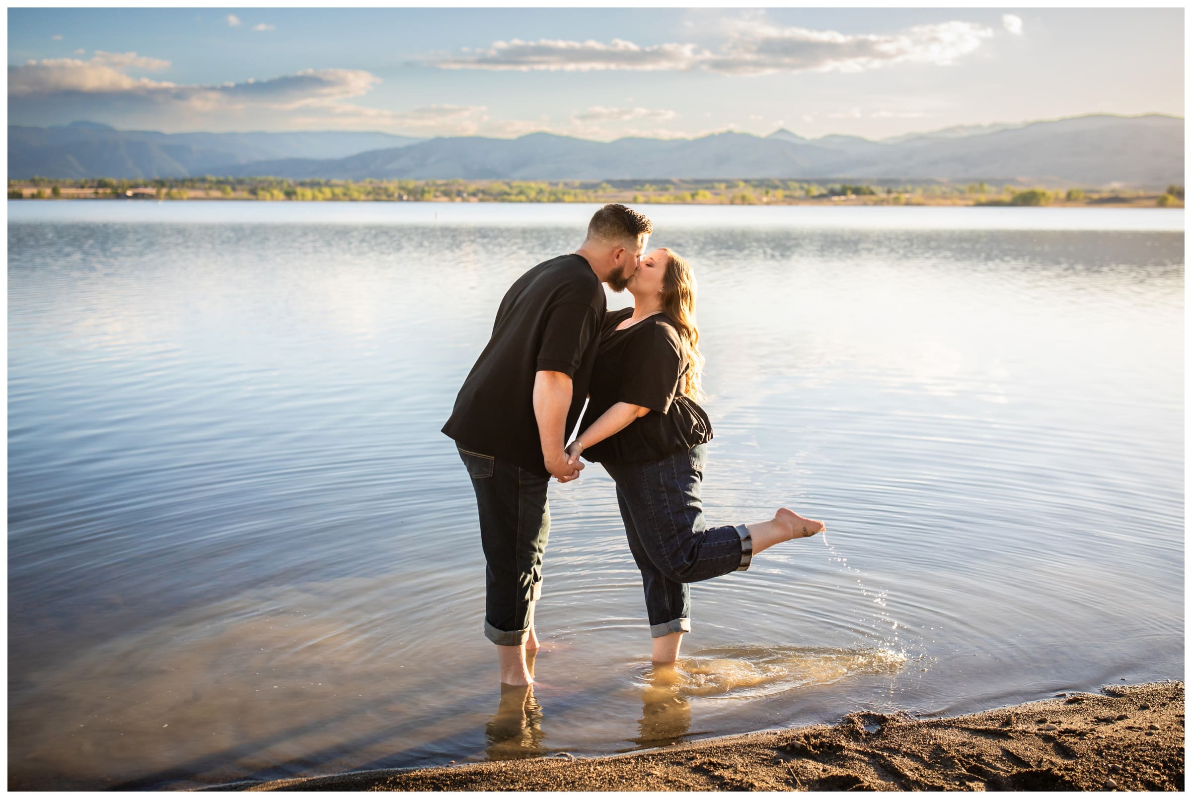 couple kissing while standing in reservoir during Boulder Colorado engagement photography session