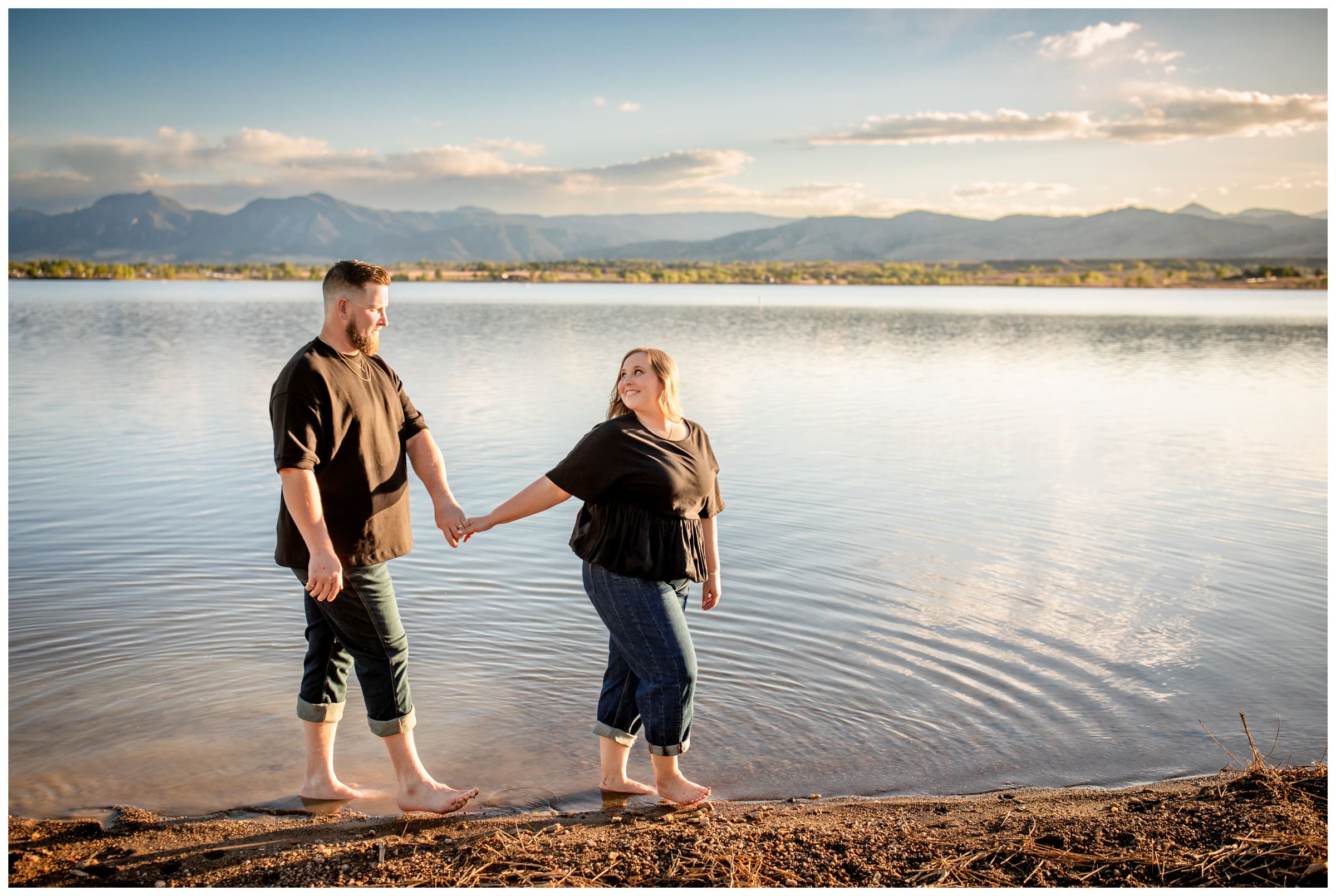 couple holding hands and walking through Boulder Reservoir during Coot Lake Colorado engagement pictures