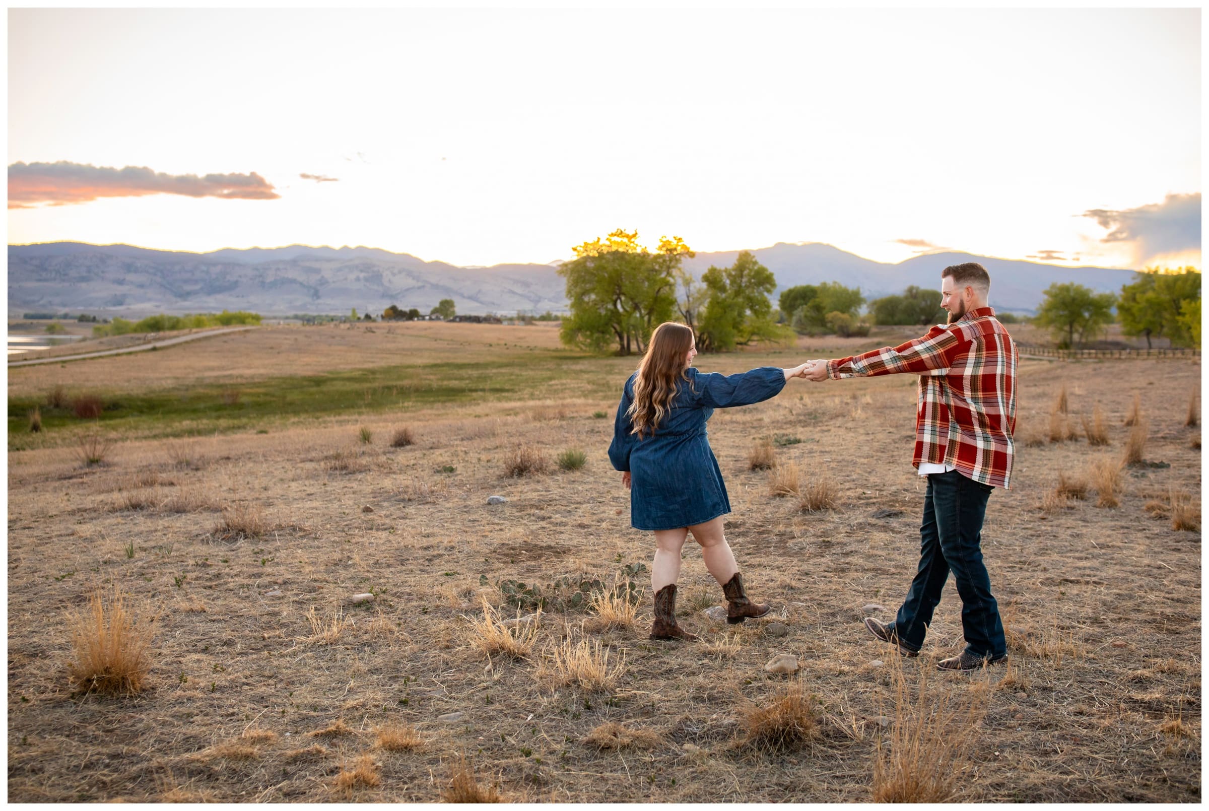 couple dancing in a mountain field during Boulder engagement pictures at Coot Lake
