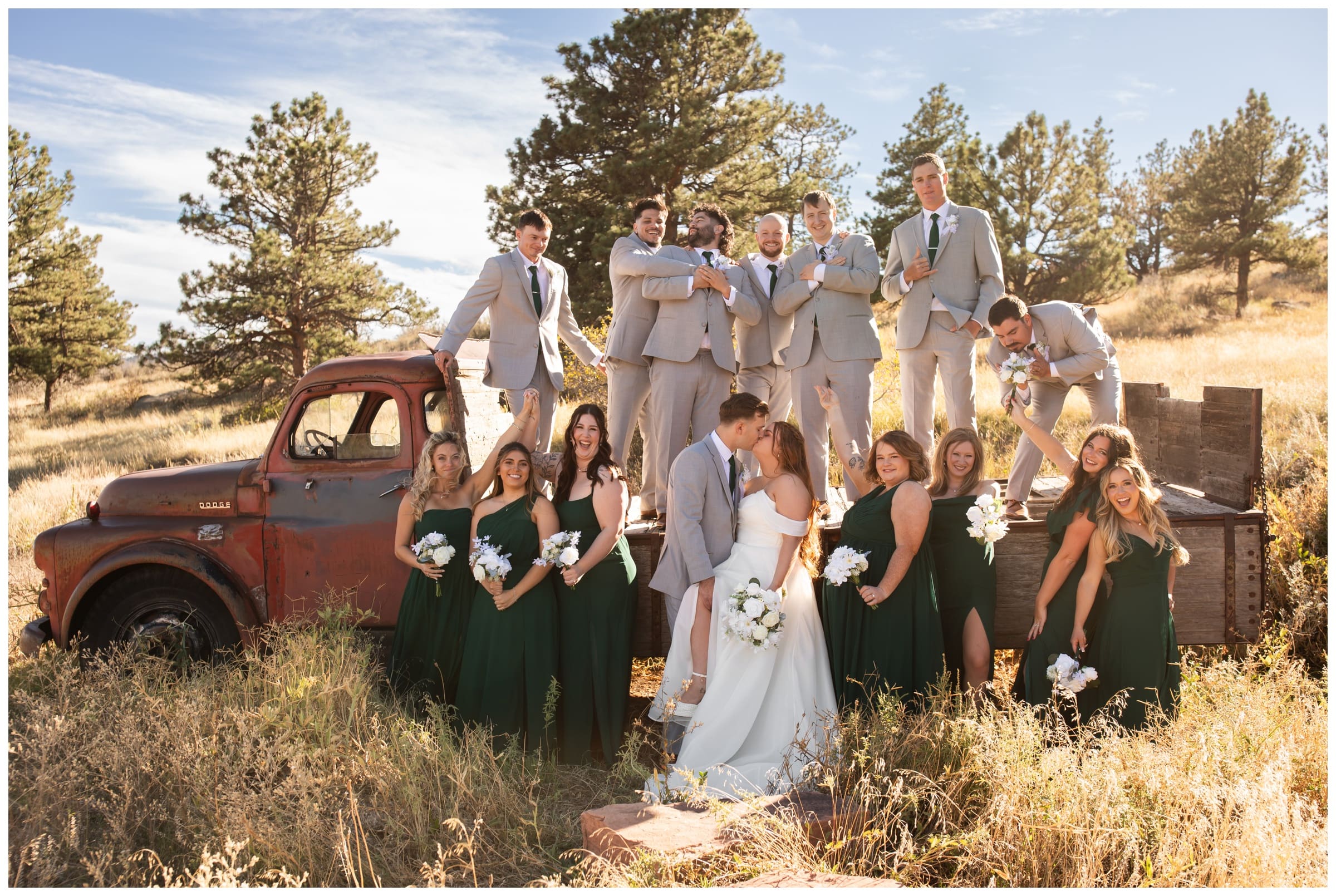 wedding party in gray and hunter green posing on vintage truck in Colorado 